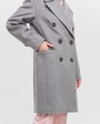 Укороченное двубортное пальто прямого кроя. Модель с английским воротником, дополнена пуговицами и клапанами на карманах. Декоративные отстрочки добавляют фактурыи делают лаконичное изделие стильным.

На модели размер XS