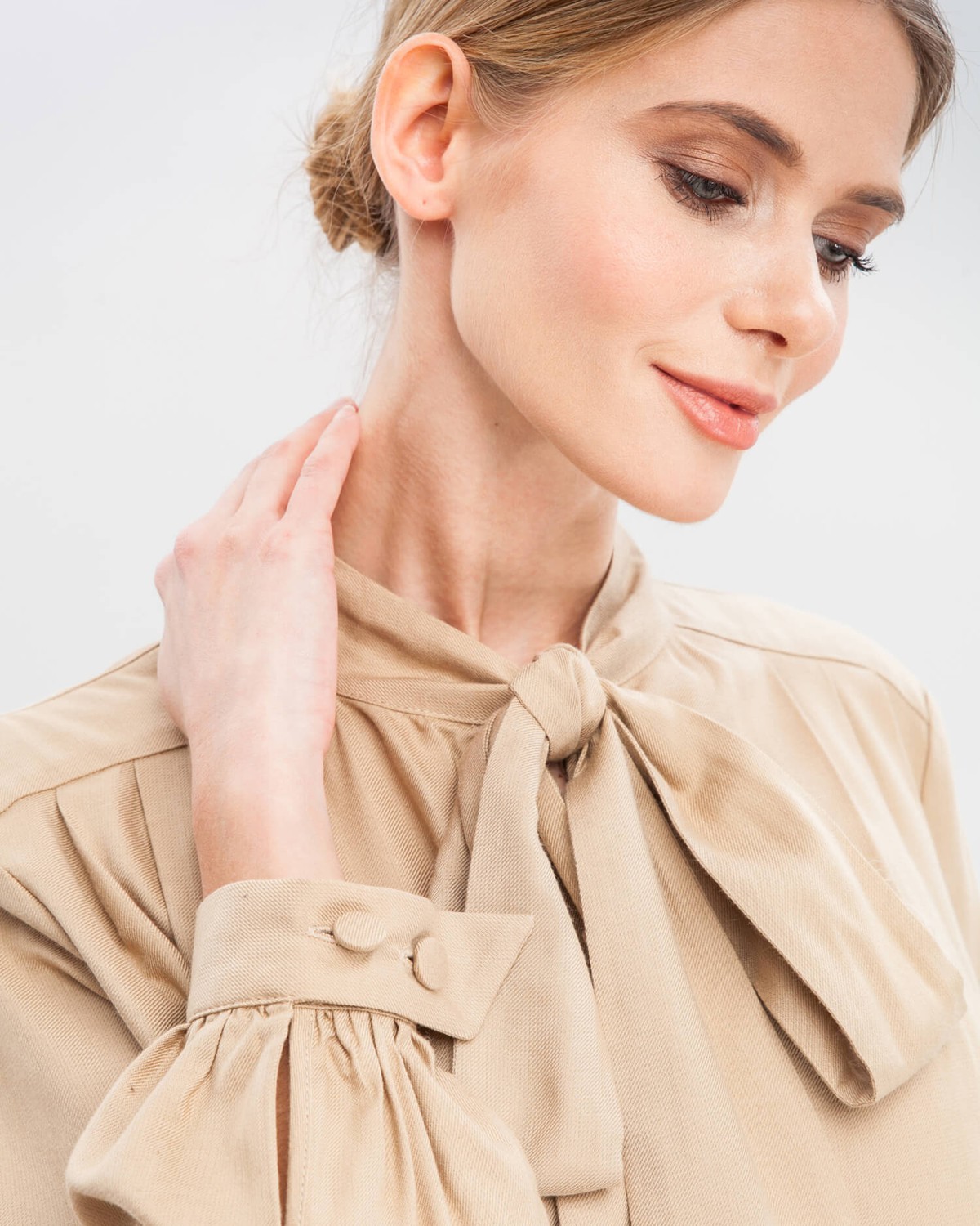 Блуза с широкими рукавами, узкими манжетами, драпировкой и бантом на груди добавит женственности любому деловому образу.
