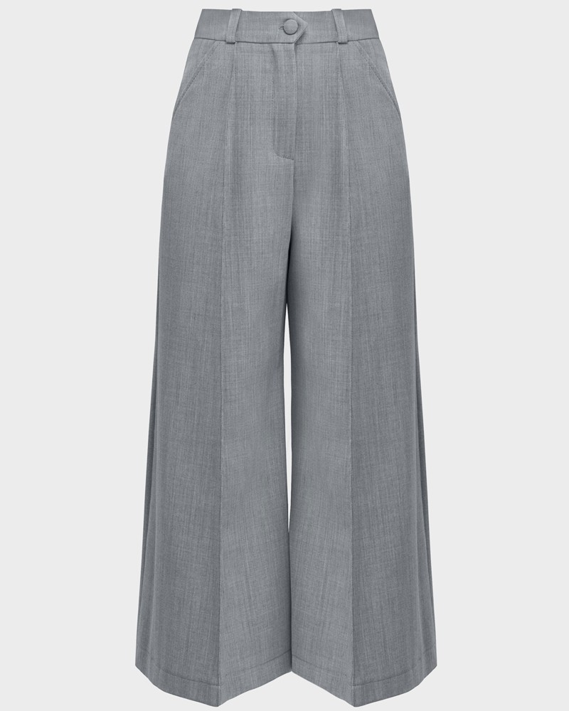 Широкие брюки-кюлоты с простроченной стрелкой и посадкой на талии. Брюки дополнены карманами, застежкой на пуговицу и молнию. За счет силуэта трапеции, который создают кюлоты, можно собирать женственные и утонченные образы.