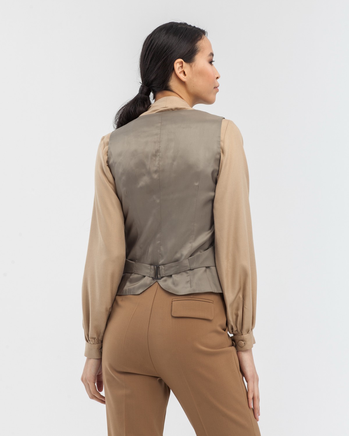 Приталенный жилет с застежкой на пуговицы. Изделие дополнено хлястиком и прорезными карманами. Жилет составит отличный комплект с жакетом и брюками в тон.

На модели размер XS