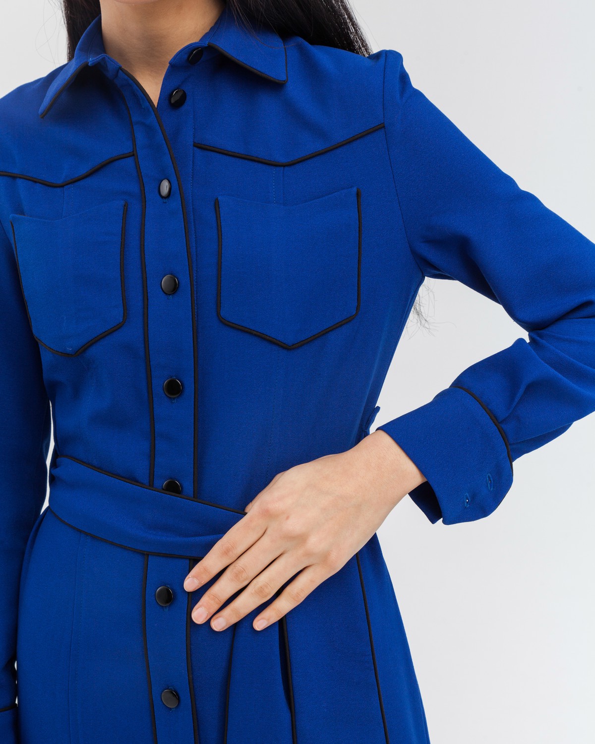 Платье-рубашка приталенного силуэта длины миди с застежкой на пуговицы дополнено поясом в тон из основного материала и кантом черного цвета. С этим платьем можно собрать множество образов, так как оно прекрасно смотрится как самостоятельно, так и в качестве накидки, дополняющей образ с водолазкой и брюками.