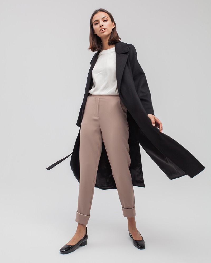 Пальто-халат с клапанами на карманах, рукавом реглан. Дополнено декоративными отстрочками и воротником-стойка с фигурным вырезом. Данная модель красиво подчеркивает женственные формы за счет пояса.