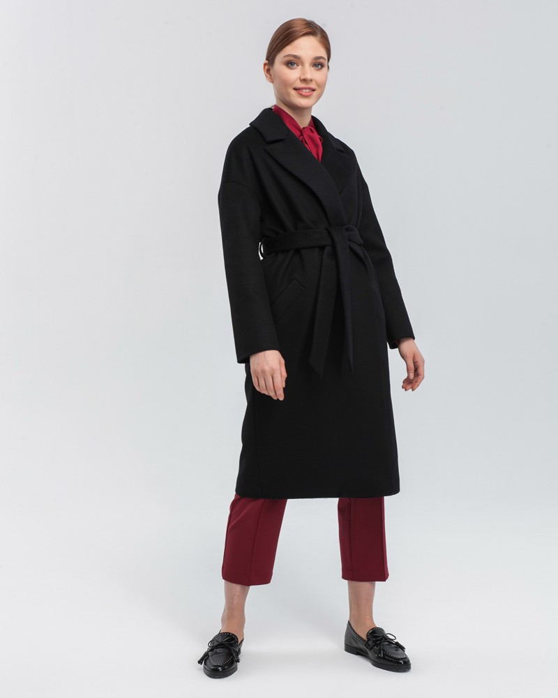 Пальто-халат с клапанами на карманах, рукавом реглан. Дополнено декоративными отстрочками и воротником-стойка с фигурным вырезом. Данная модель красиво подчеркивает женственные формы за счет пояса.

На модели размер XS