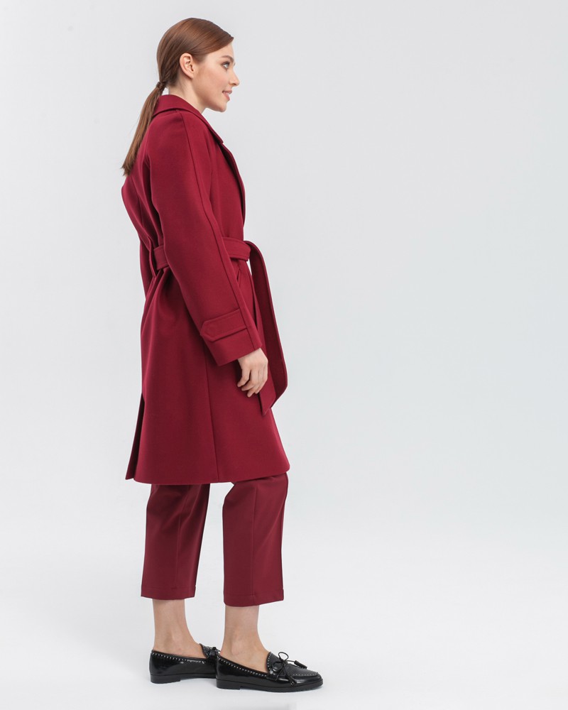 Пальто-халат длины мини с клапанами на карманах, рукавом реглан. Дополнено декоративными отстрочками и воротником-стойка с фигурным вырезом. Данная модель красиво подчеркивает женственные формы за счет пояса.