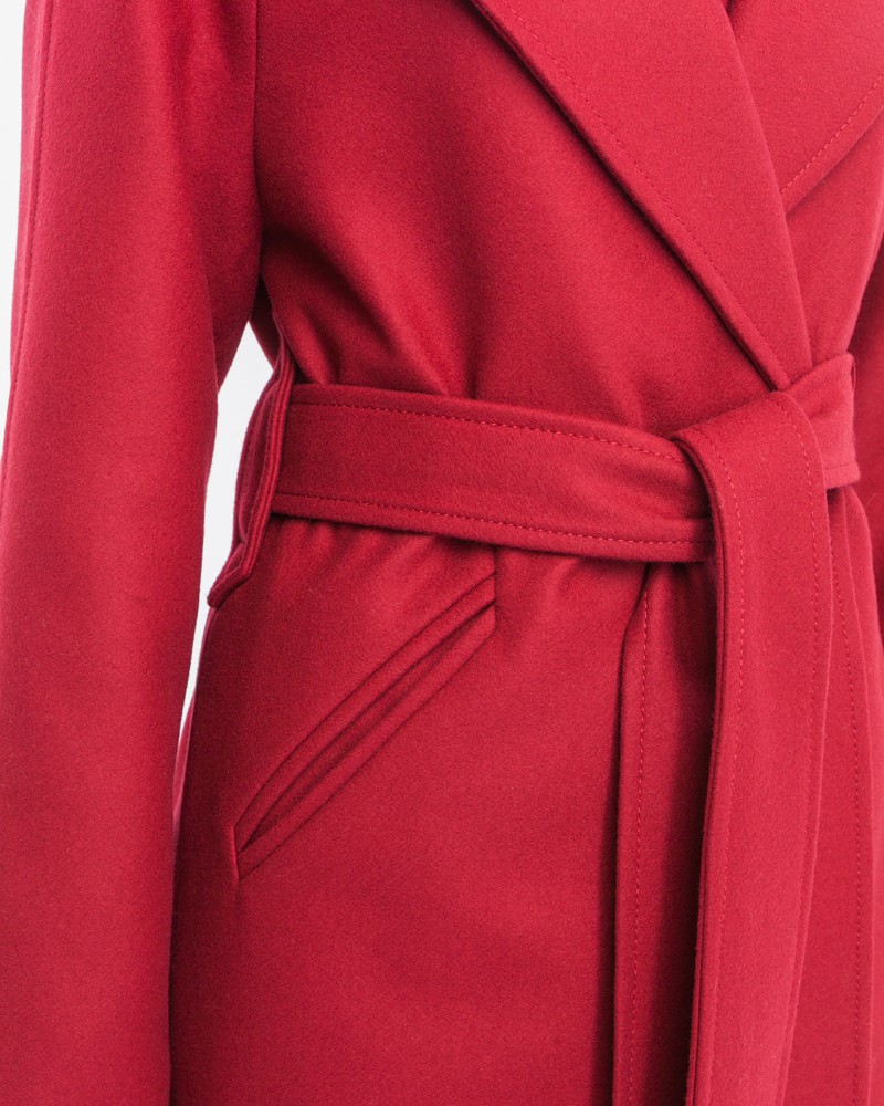 Пальто-халат длины мини с клапанами на карманах, рукавом реглан. Дополнено декоративными отстрочками и воротником-стойка с фигурным вырезом. Данная модель красиво подчеркивает женственные формы за счет пояса.