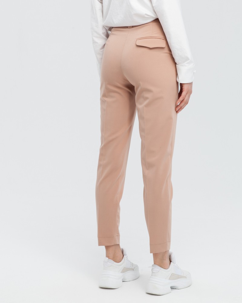 Зауженные к низу брюки полуприлегающего силуэта со средней посадкой и застежкой на молнию и крючки. Посадка на талии и стрелка визуально удлиняют ноги и делают ваш образ более собранным и элегантным.