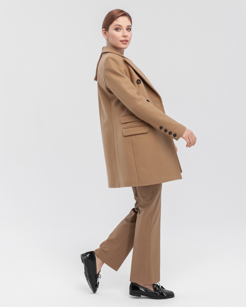 Двубортное укороченное пальто из плотной шерсти с кашемиром. Модель имеет английский воротник, дополнена тремя карманами с клапанами. Отличительная особенность данной модели - шлица по рукаву на 4 пуговицы. Пуговицы выкрашены вручную.

На модели размер XS