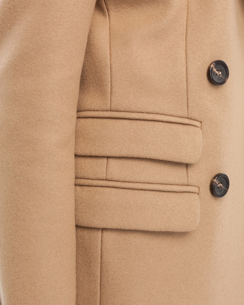 Двубортное укороченное пальто из плотной шерсти с кашемиром. Модель имеет английский воротник, дополнена тремя карманами с клапанами. Отличительная особенность данной модели - шлица по рукаву на 4 пуговицы. Пуговицы выкрашены вручную.

На модели размер XS