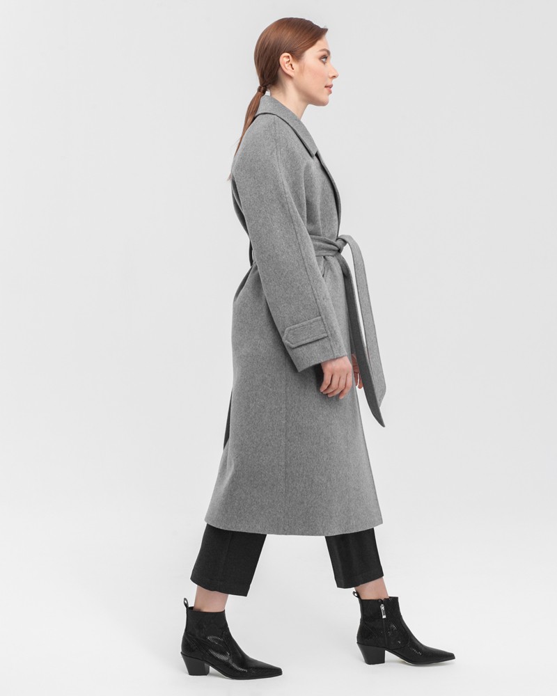 Пальто-халат с клапанами на карманах, рукавом реглан. Дополнено декоративными отстрочками и воротником-стойка с фигурным вырезом. Данная модель красиво подчеркивает женственные формы за счет пояса.

На модели размер XS