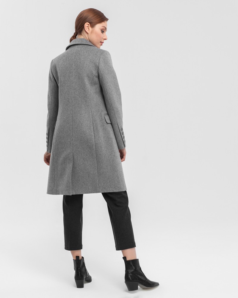 Двубортное укороченное пальто из плотной шерсти с кашемиром. Модель имеет английский воротник, дополнена карманами с клапанами. Отличительная особенность данной модели - шлица по рукаву на 4 пуговицы. Пуговицы выкрашены вручную.

На модели размер XS