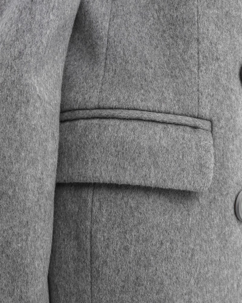 Двубортное укороченное пальто из плотной шерсти с кашемиром. Модель имеет английский воротник, дополнена карманами с клапанами. Отличительная особенность данной модели - шлица по рукаву на 4 пуговицы. Пуговицы выкрашены вручную.

На модели размер XS