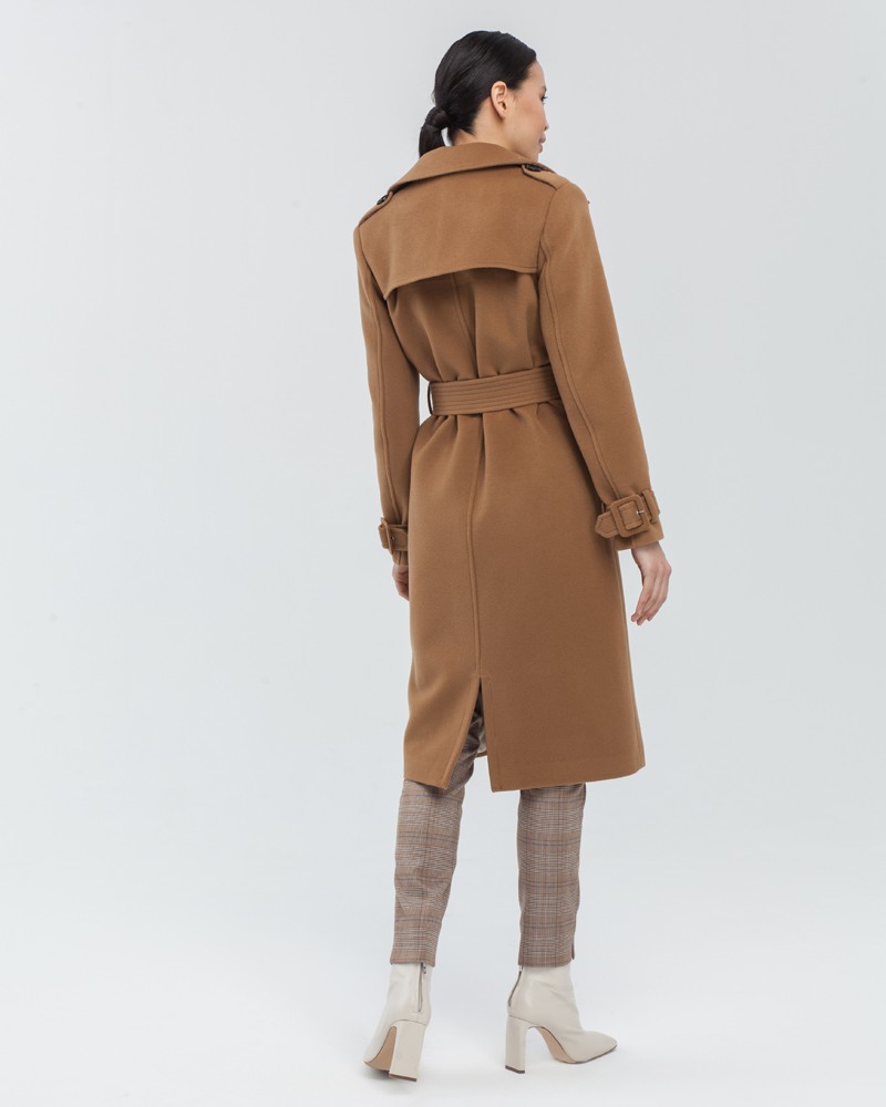 Двубортное пальто-тренч классической посадки с застежкой на пуговицы. Дополнено простроченным поясом с обтяжной пряжкой в тон изделия и отлетной кокеткой на спинке. Застежка на вороте позволяет запахнуть ворот и защищает от сильного ветра.