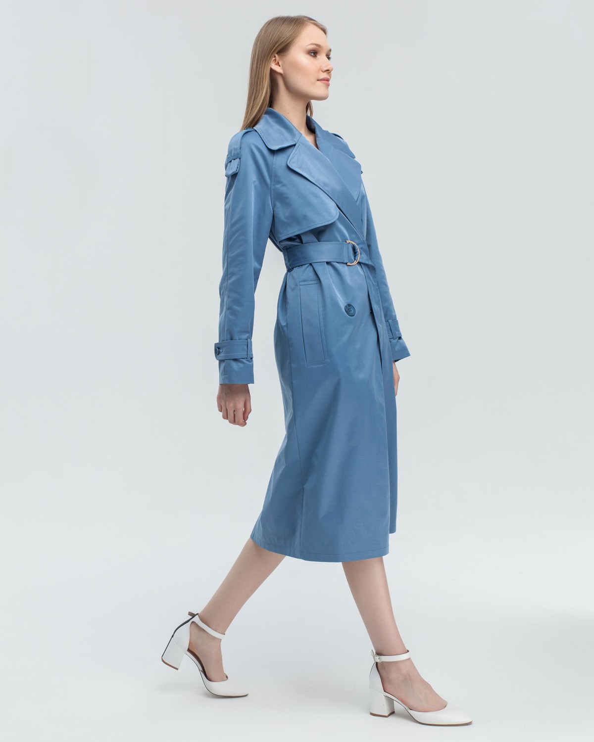 Тренч классической посадки с рукавом реглан. Дополнен погонами, патами на рукавах и поясом в тон изделия с металлической пряжкой. Выполнен из плащевой ткани с добавалением хлопка, на подкладке. Защитит от ветра весенними вечерами.
