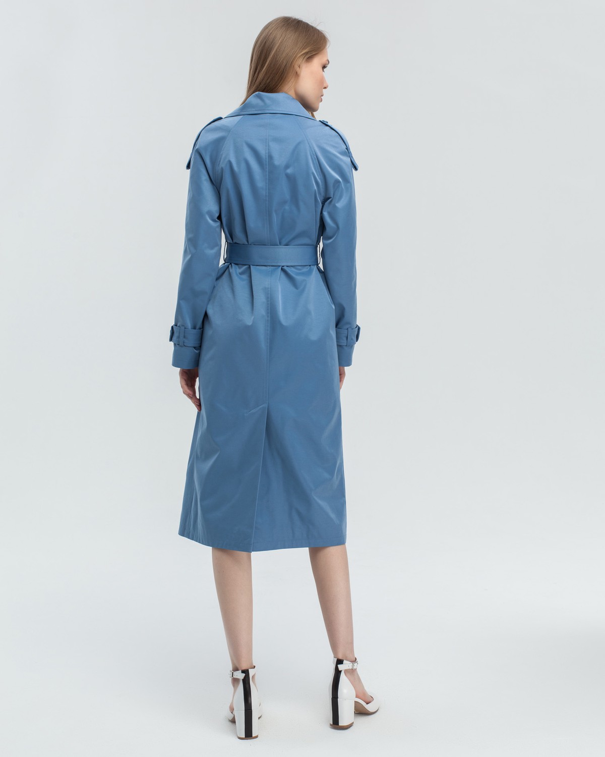 Тренч классической посадки с рукавом реглан. Дополнен погонами, патами на рукавах и поясом в тон изделия с металлической пряжкой. Выполнен из плащевой ткани с добавалением хлопка, на подкладке. Защитит от ветра весенними вечерами.