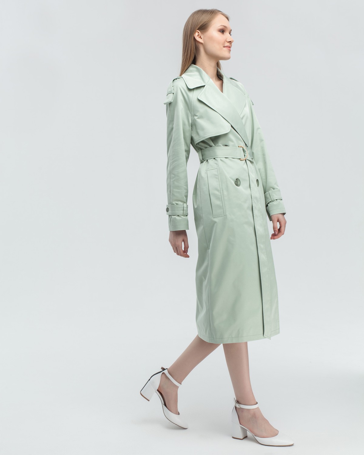 Тренч классической посадки с рукавом реглан. Дополнен погонами, патами на рукавах и поясом в тон изделия с металлической пряжкой. Выполнен из плащевой ткани с добавалением хлопка, на подкладке. Защитит от ветра весенними вечерами.