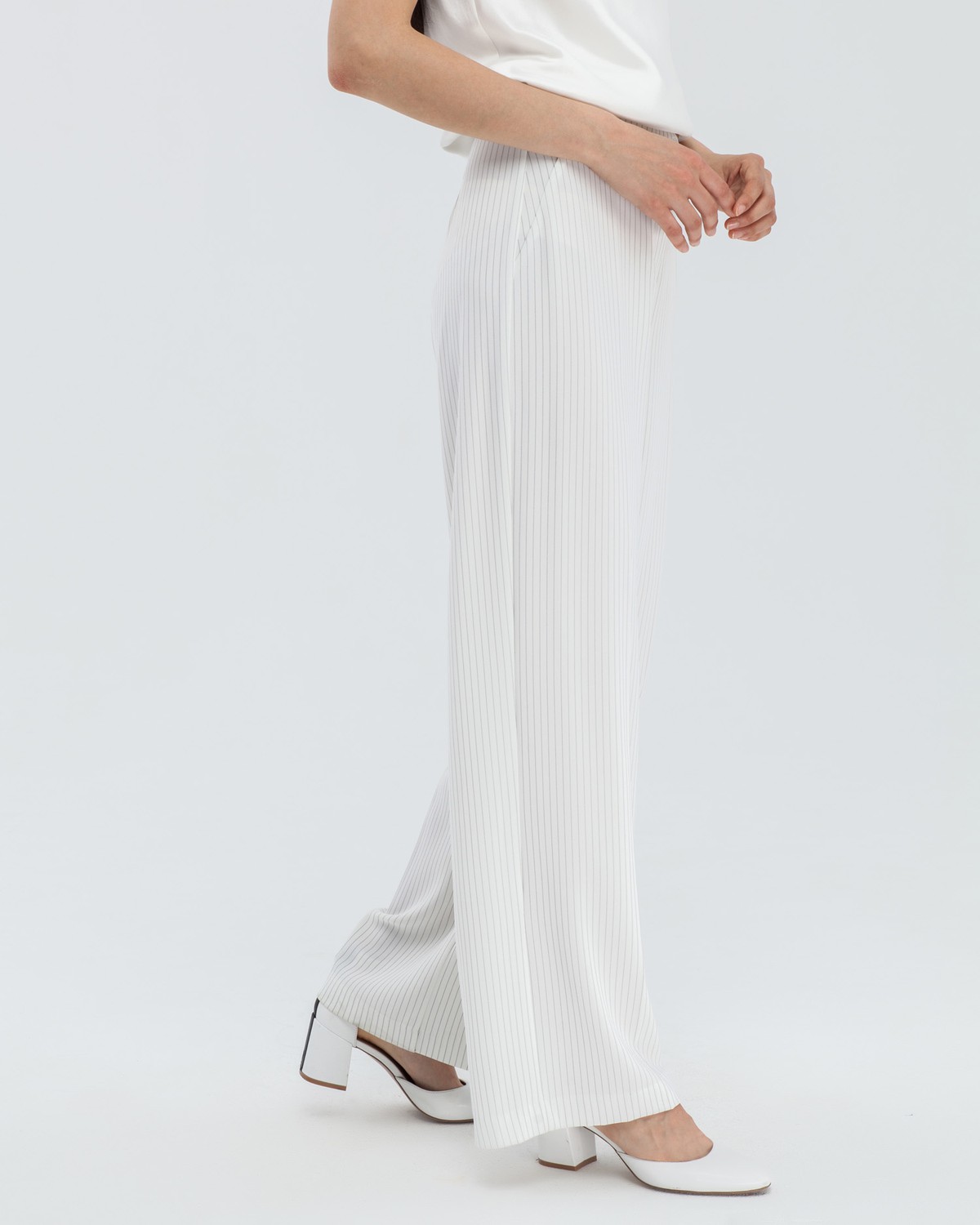 Широкие брюки на высокой талии с затёжкой на две пуговицы и молнию. В сочетаниис обувью на каблуках удлиняют ноги и вытягивают рост.

На модели размер XS