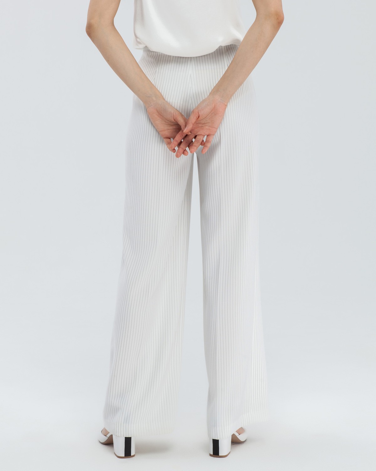 Широкие брюки на высокой талии с затёжкой на две пуговицы и молнию. В сочетаниис обувью на каблуках удлиняют ноги и вытягивают рост.

На модели размер XS