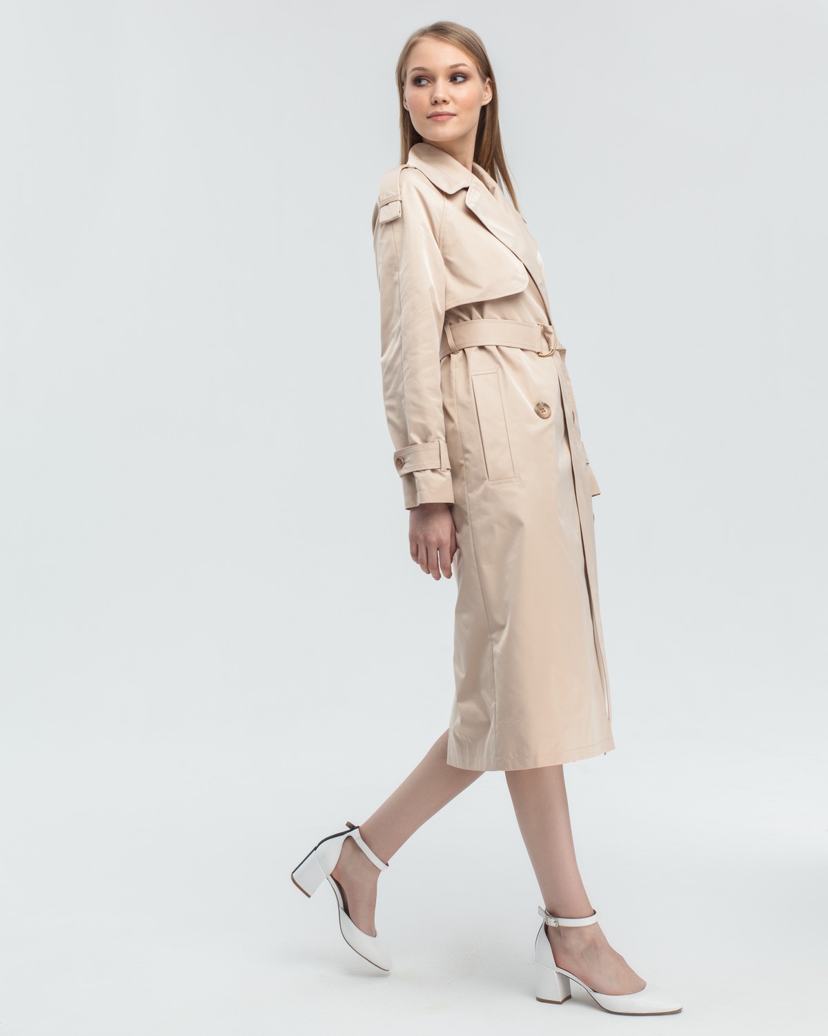 Тренч классической посадки с рукавом реглан. Дополнен погонами, патами на рукавах и поясом в тон изделия с металлической пряжкой. Выполнен из плащевой ткани с добавалением хлопка, на подкладке. Защитит от ветра весенними вечерами.