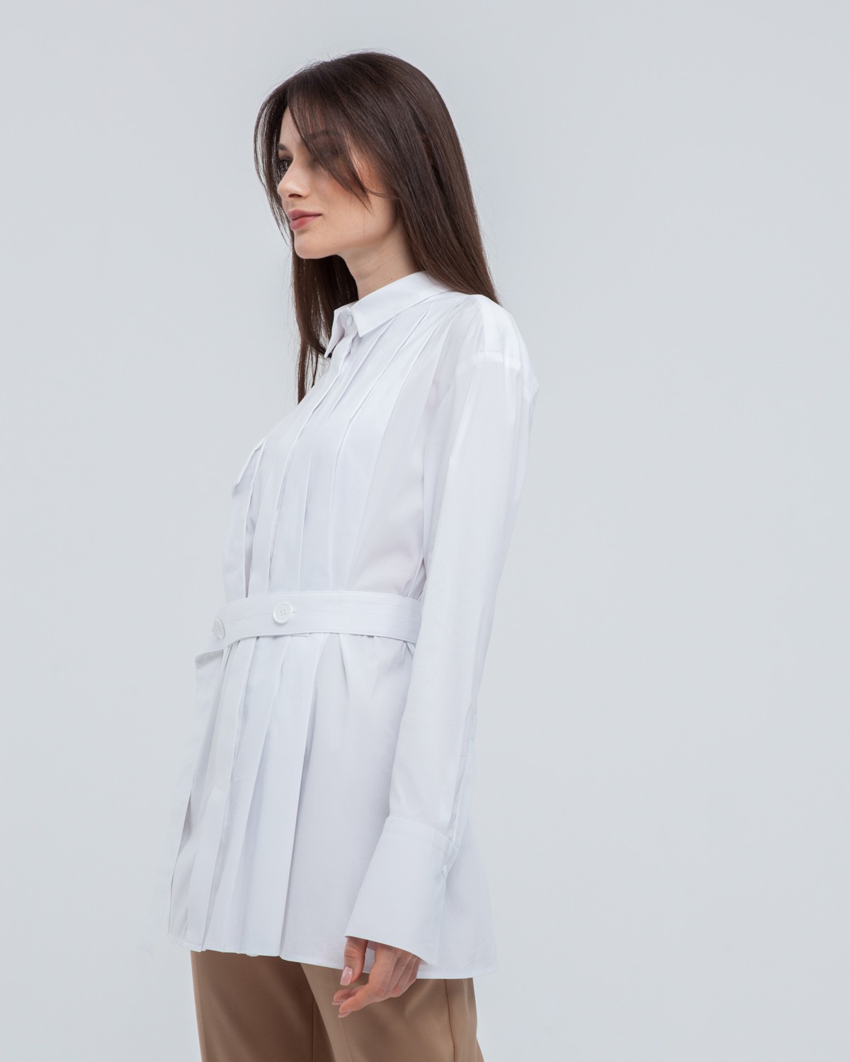 Акцентная удлиненная рубашка с объемным накладным карманом и плиссировкой по левому боку. Дополнена поясом на пуговицах в тон изделия. Модель позволяет носить ее как с поясом, так и без. Идеальный вариант для создания уникального делового или повседневного образа.

На модели размер XS