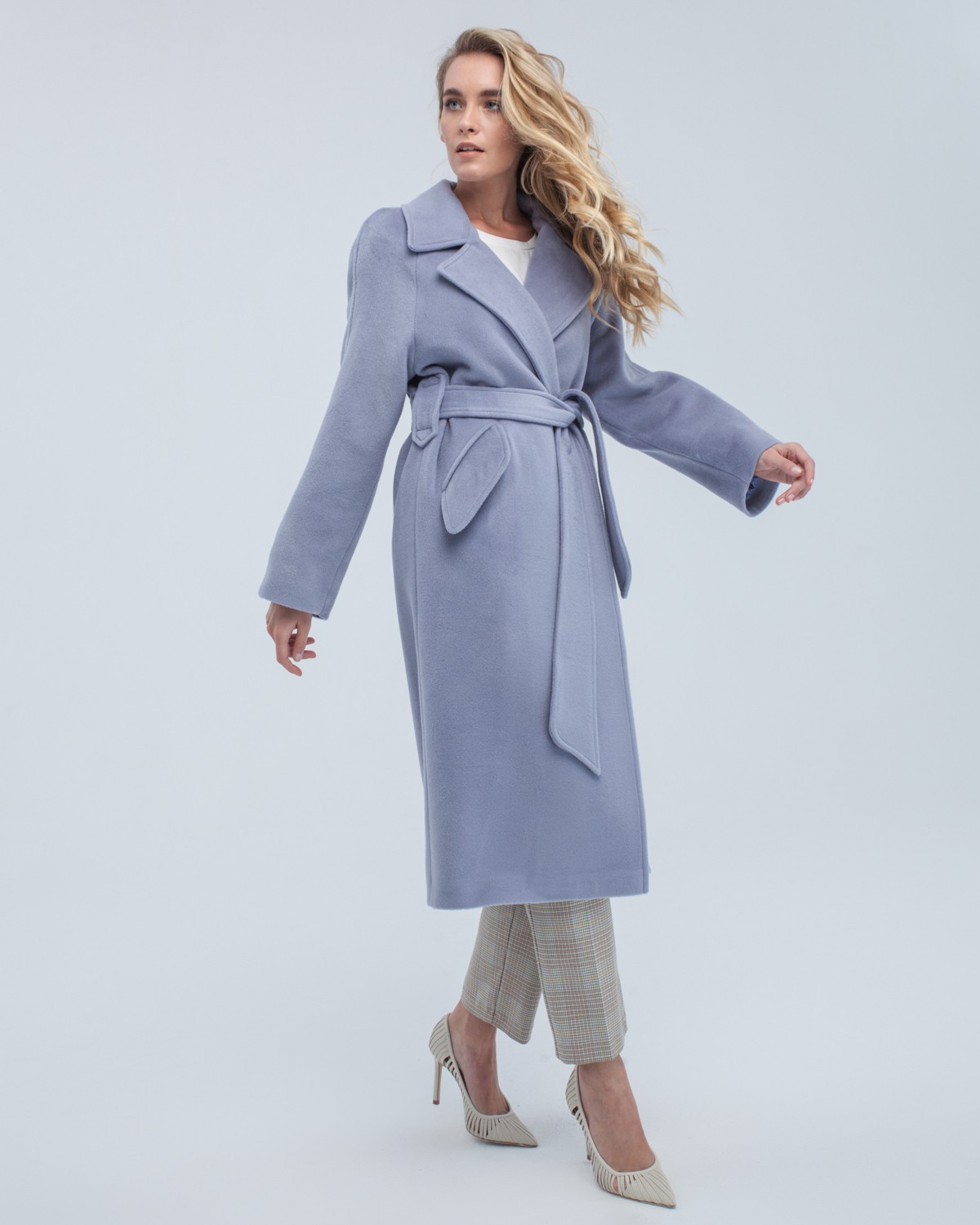 Пальто-халат длины миди с клапанами на карманах, рукавом реглан. Дополнено декоративными отстрочками и воротником-стойка с фигурным вырезом. Данная модель красиво подчеркивает женственные формы за счет пояса.

На модели размер XS