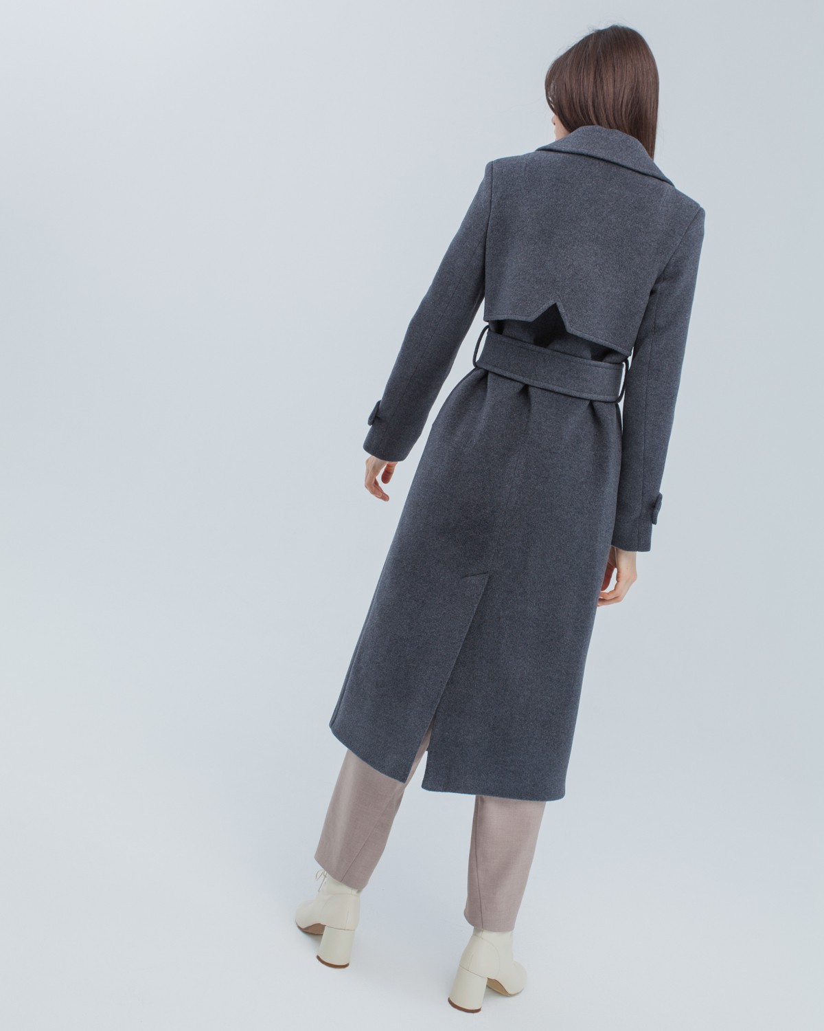 Двубортное пальто-тренчс кокеткой по спинке, широким поясом на пуговицах и шлицей сзади.
Рукава декорированы патами на пуговицах. Классический крой в сочетании с элементами стиля милитари - отличная альтернатива минимализму.

На модели размер XS