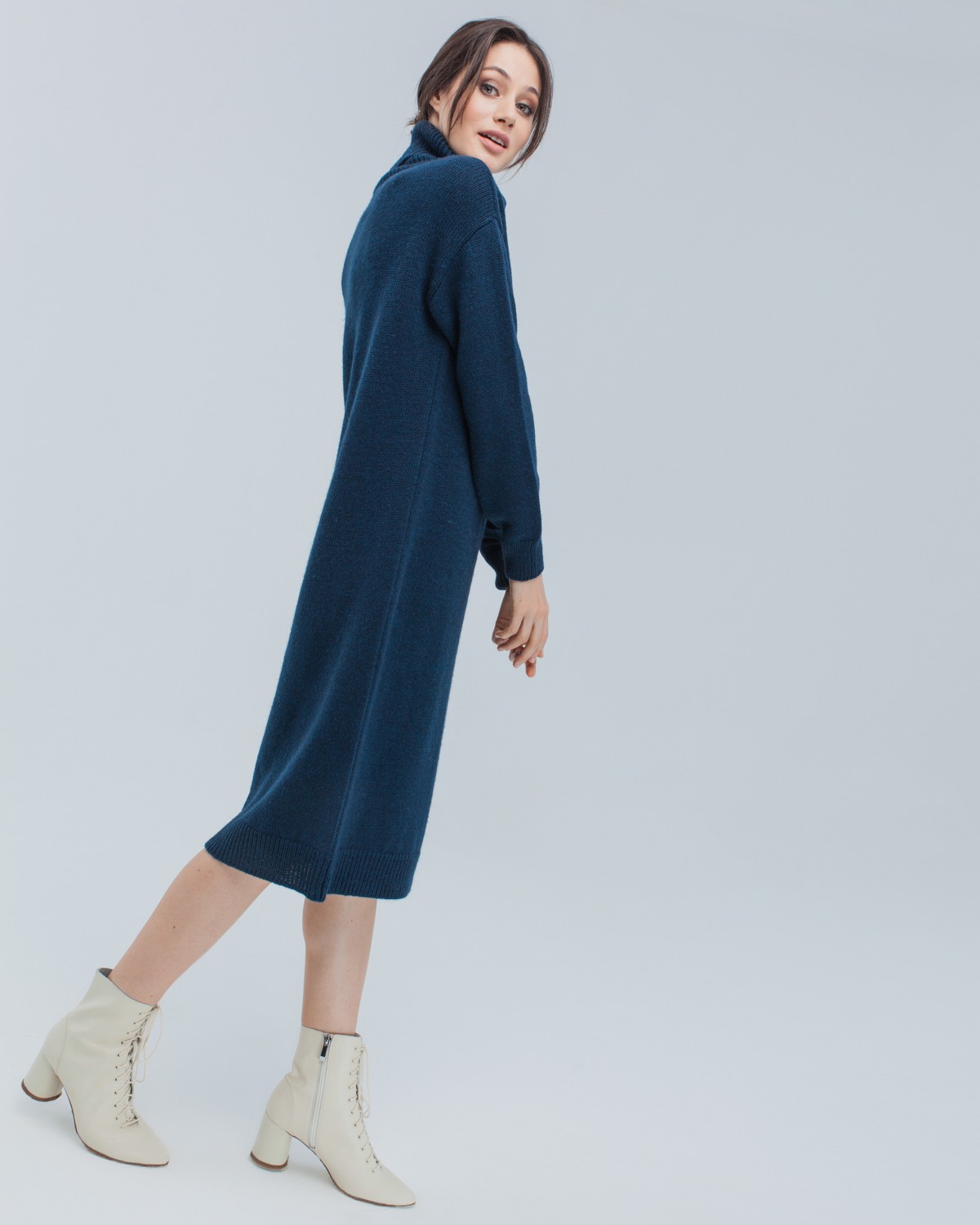 Трикотажное платье длины миди прямого кроя. Дополнено широким высоким воротом. По низу рукава и низу изделия притачан манжет, что создает удобство при ношении платья. Идеальный вариант для прохладных зимнихпрогулок и уютных посиделок с друзьями.