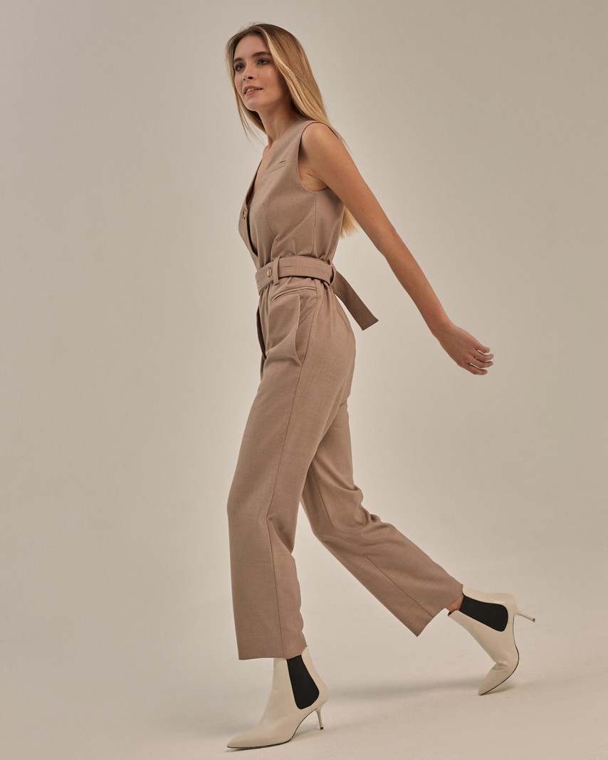 Комбинезон прямого силуэта с V-образным вырезом и укороченными штанинами. Модель дополнена пуговицей на передней части из полиэфира. Комбинезон со съемным поямом с 2 акцентными роговыми пуговицами. Можно сочетать как с лодочками для элегантного образа, так и с кроссовками для расслабленного лука.

На модели размер XS