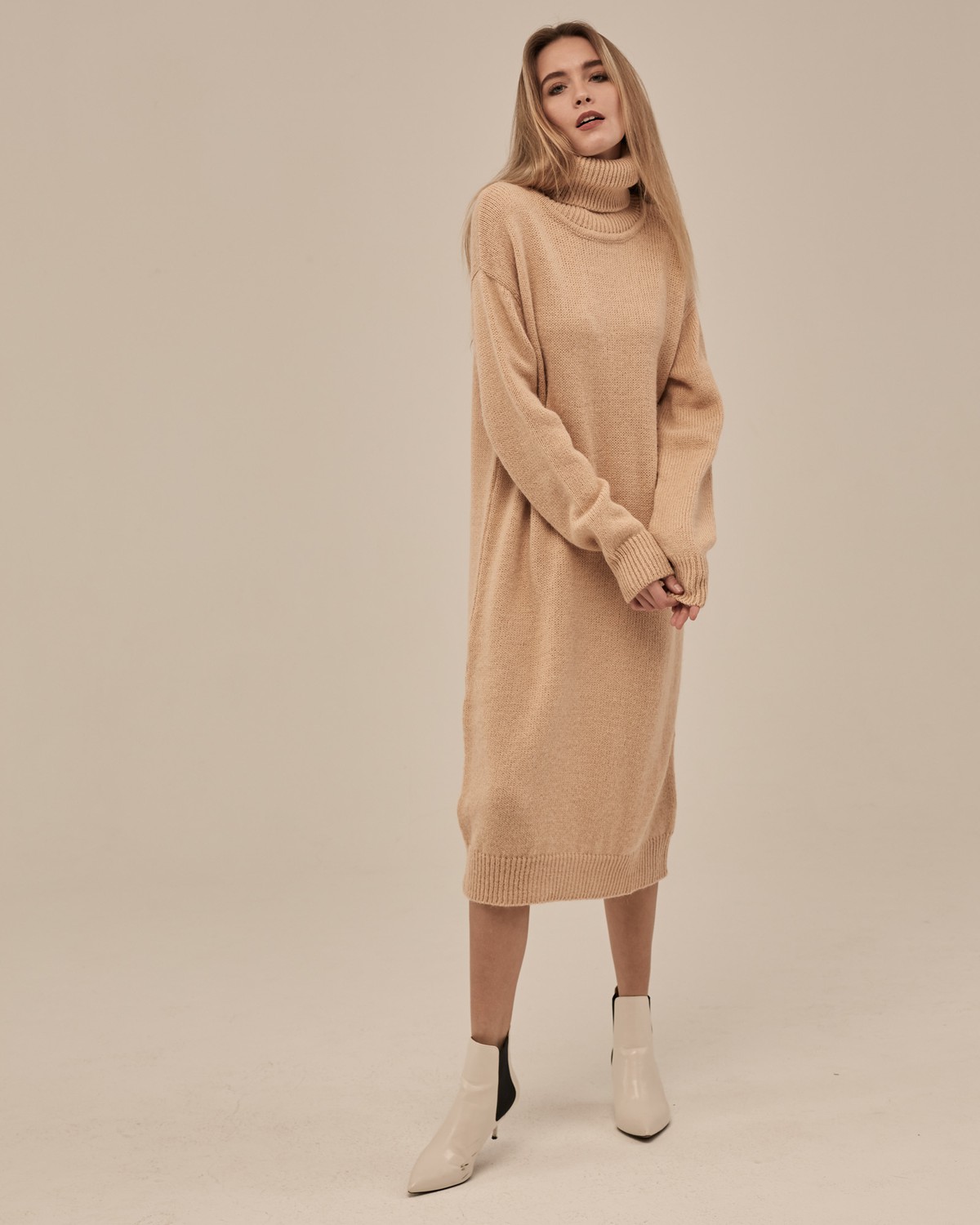 Трикотажное платье длины миди прямого кроя. Дополнено широким высоким воротом. По низу рукава и низу изделия притачан манжет, что создает удобство при ношении платья. Идеальный вариант для прохладных зимнихпрогулок и уютных посиделок с друзьями.
