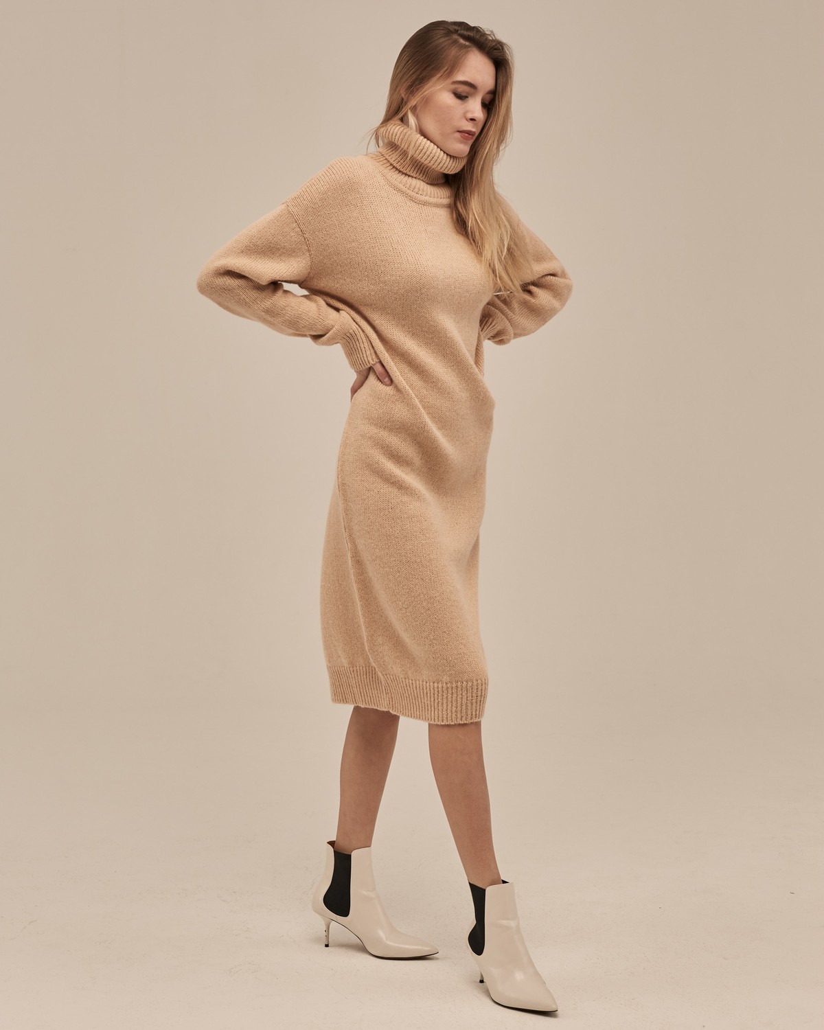 Трикотажное платье длины миди прямого кроя. Дополнено широким высоким воротом. По низу рукава и низу изделия притачан манжет, что создает удобство при ношении платья. Идеальный вариант для прохладных зимнихпрогулок и уютных посиделок с друзьями.