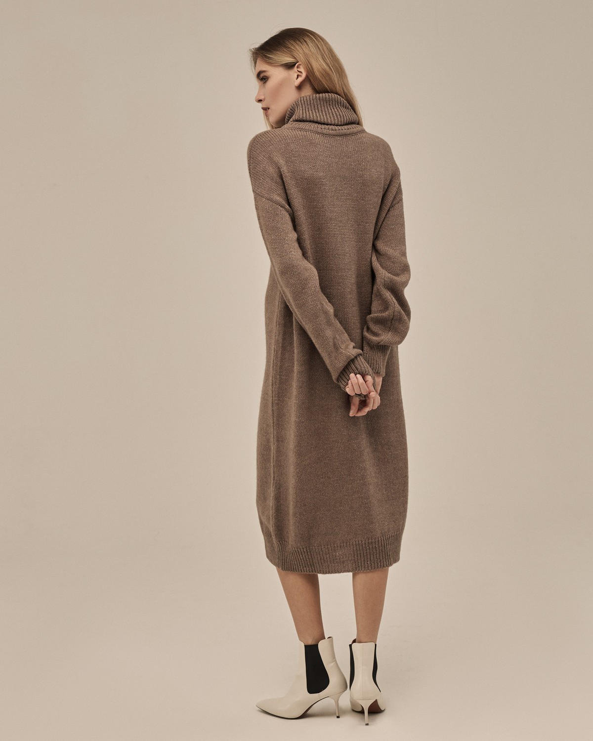 Трикотажное платье длины миди прямого кроя. Дополнено широким высоким воротом. По низу рукава и низу изделия притачан манжет, что создает удобство при ношении платья. Идеальный вариант для прохладных зимнихпрогулок и уютных посиделок с друзьями.