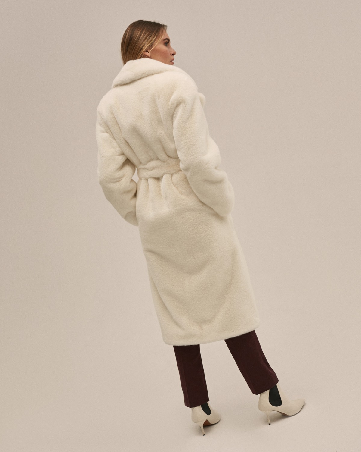 Шуба из искусственного меха прямого кроя длины миди с рукавом реглан и английским воротником. Модель дополнена поясом из основного материала и застегивается на крючки.

Температурный режим: до -10 градусов

На модели размер XS