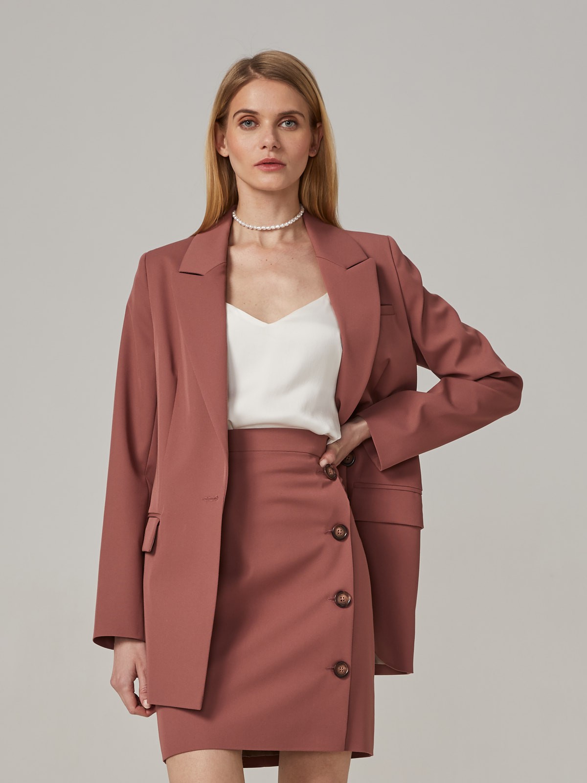 Прямая юбка длины мини на высокой посадке. модель дополнена 4 декоративными пуговицами по левому боку. Верхний срез обработан отрезным поясом.
Цветомодели кэмел и терракотовый на 35% выполнены из переработанного пластика.

На модели размер XS

