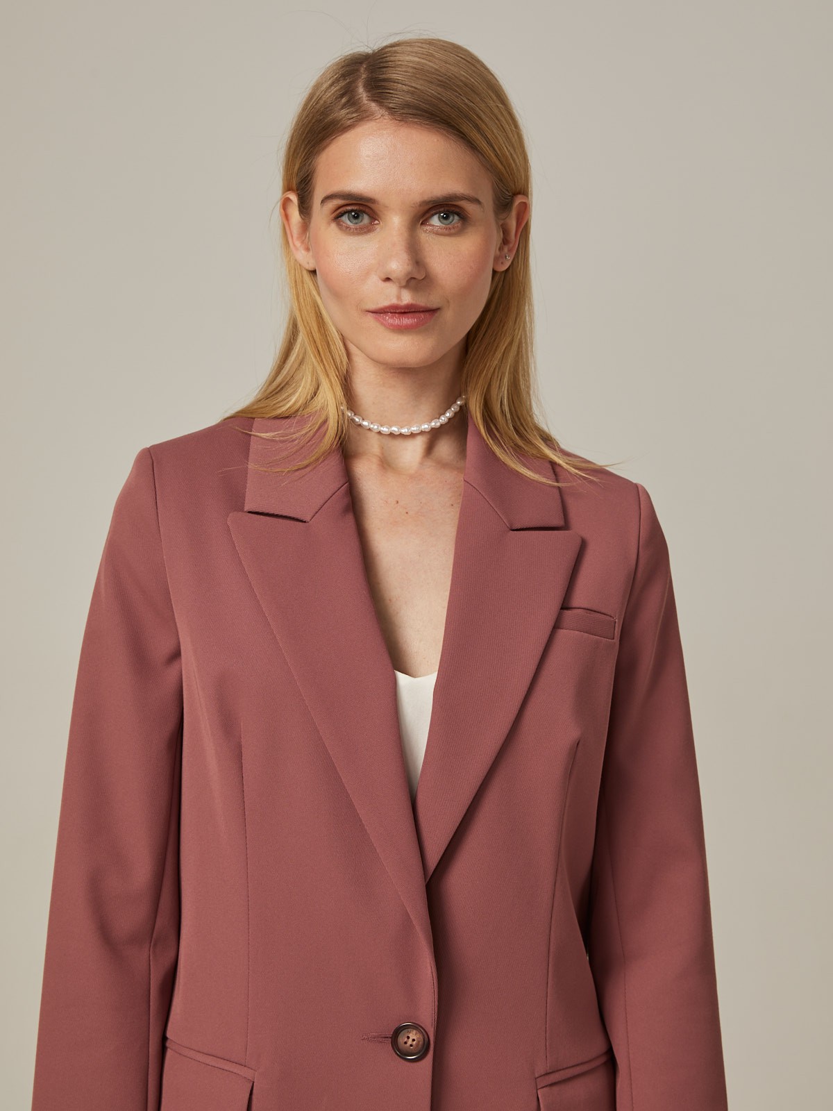 Удлиненный однобортный жакетс плечевыми накладками. Крой oversize дает отсылку к стилю мужского пиджака. Модель полуприталенного силуэта подчеркивает женственность фигуры. Жакет можно сочетать с брюками в тон, узкой юбкой или джинсами.
Цветомодели кэмел и терракотовый на 35% выполнены из переработанного пластика.

На модели размер XS