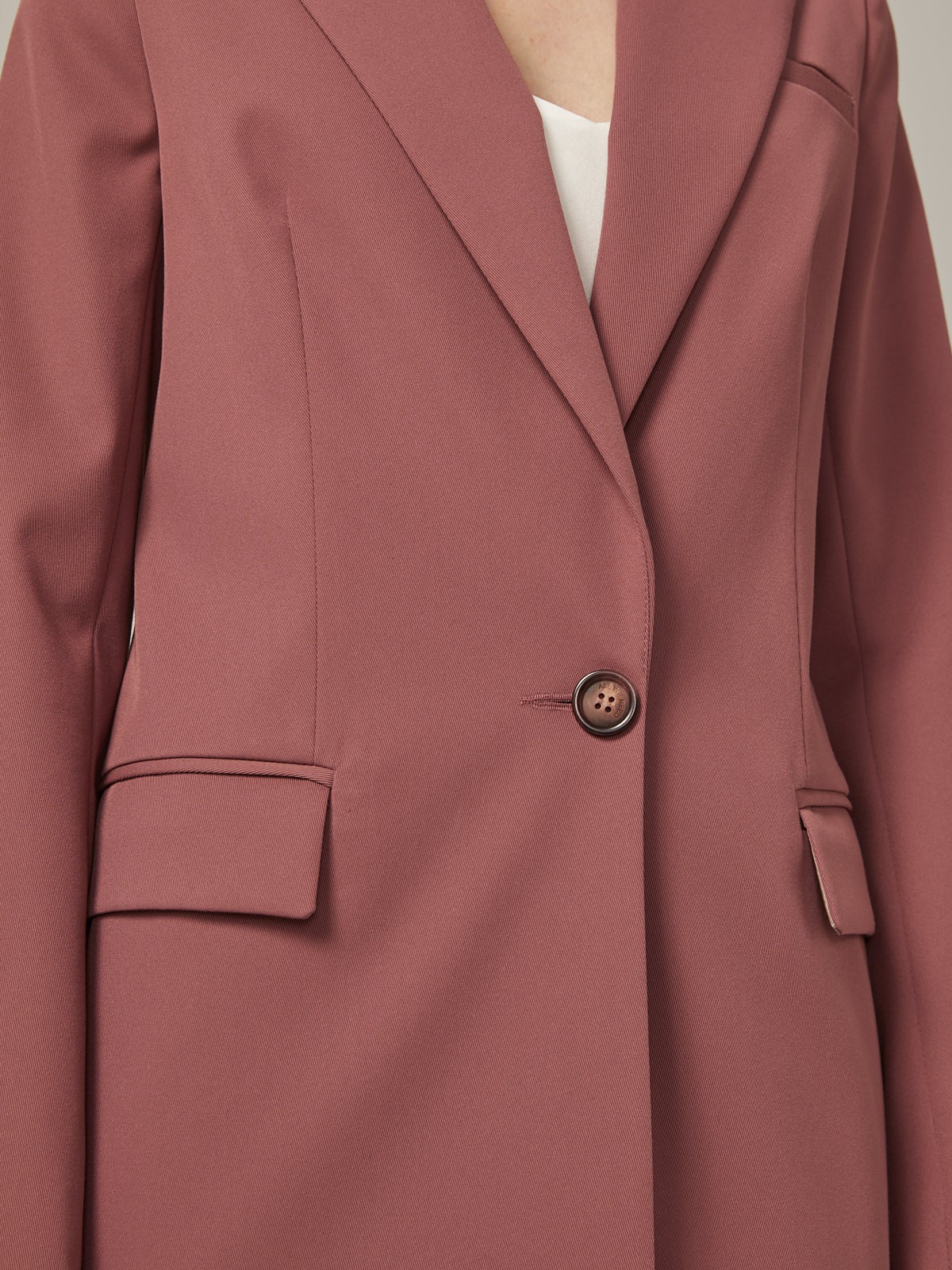 Удлиненный однобортный жакетс плечевыми накладками. Крой oversize дает отсылку к стилю мужского пиджака. Модель полуприталенного силуэта подчеркивает женственность фигуры. Жакет можно сочетать с брюками в тон, узкой юбкой или джинсами.
Цветомодели кэмел и терракотовый на 35% выполнены из переработанного пластика.

На модели размер XS