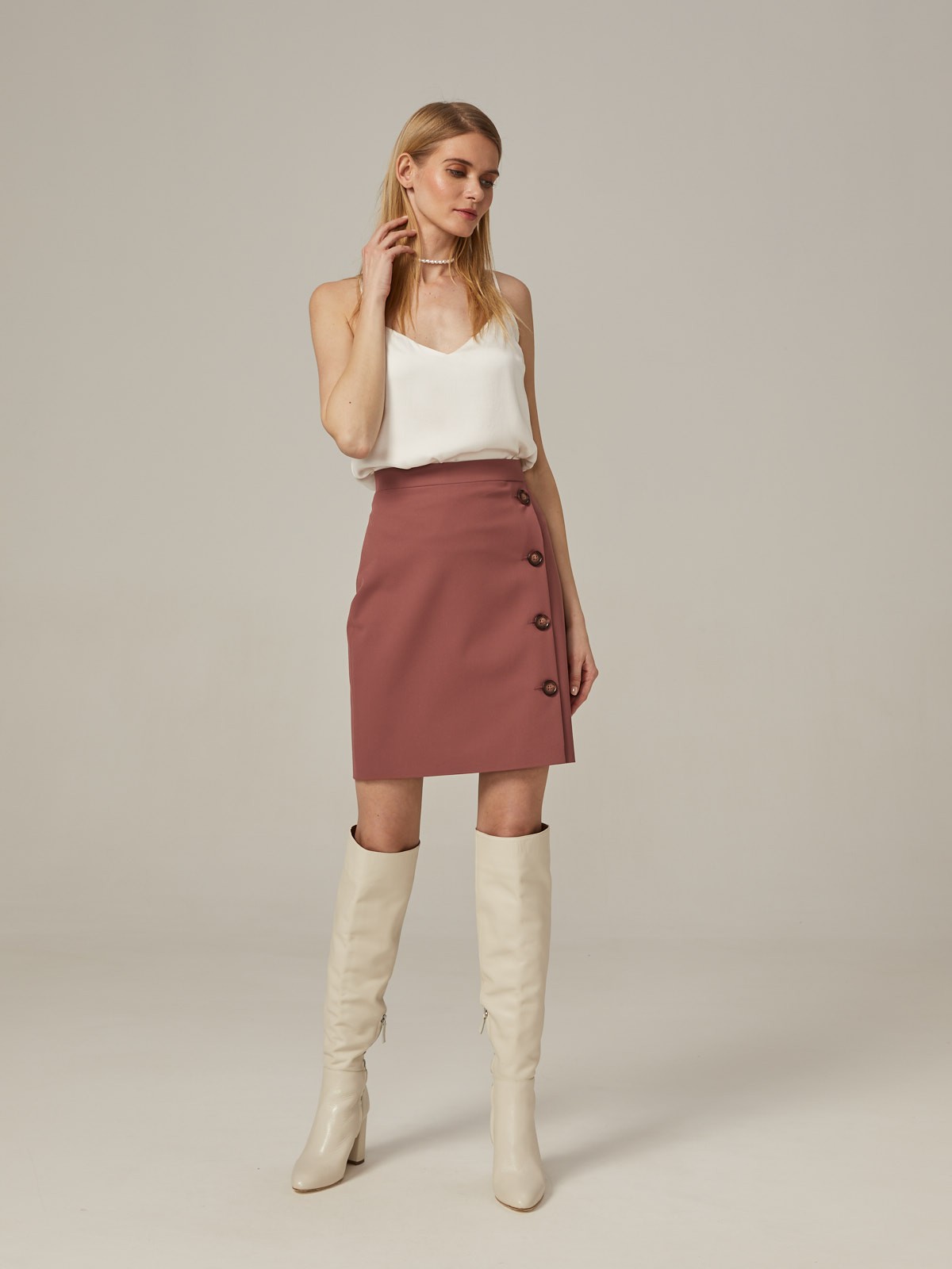 Прямая юбка длины мини на высокой посадке. модель дополнена 4 декоративными пуговицами по левому боку. Верхний срез обработан отрезным поясом.
Цветомодели кэмел и терракотовый на 35% выполнены из переработанного пластика.

На модели размер XS

