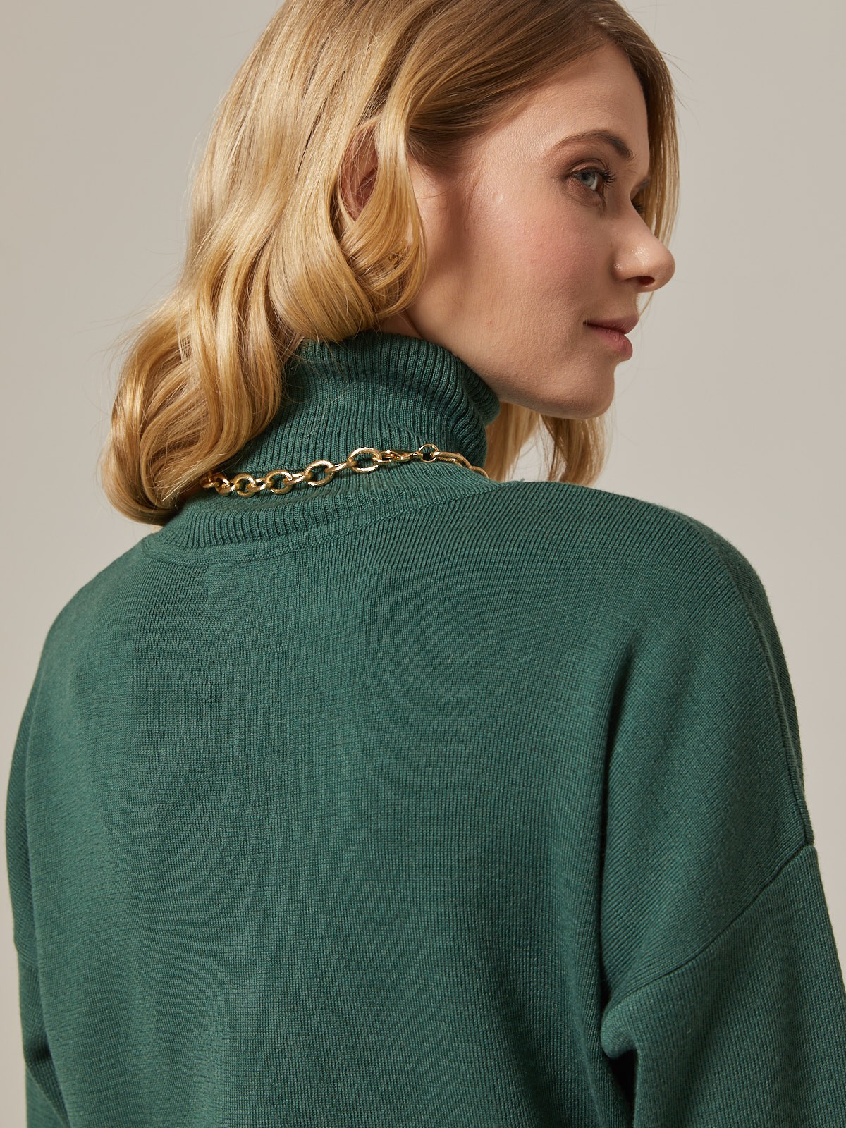 Костюм из вязанного трикотажа, состоящий из юбки с кофтой. Юбка прямая, зауженная к низу. Дополнена разрезом по шву с левой стороны. Кофта прямая со спущенным плечом, дополнена воротником-стойкой.

На модели размер M/L