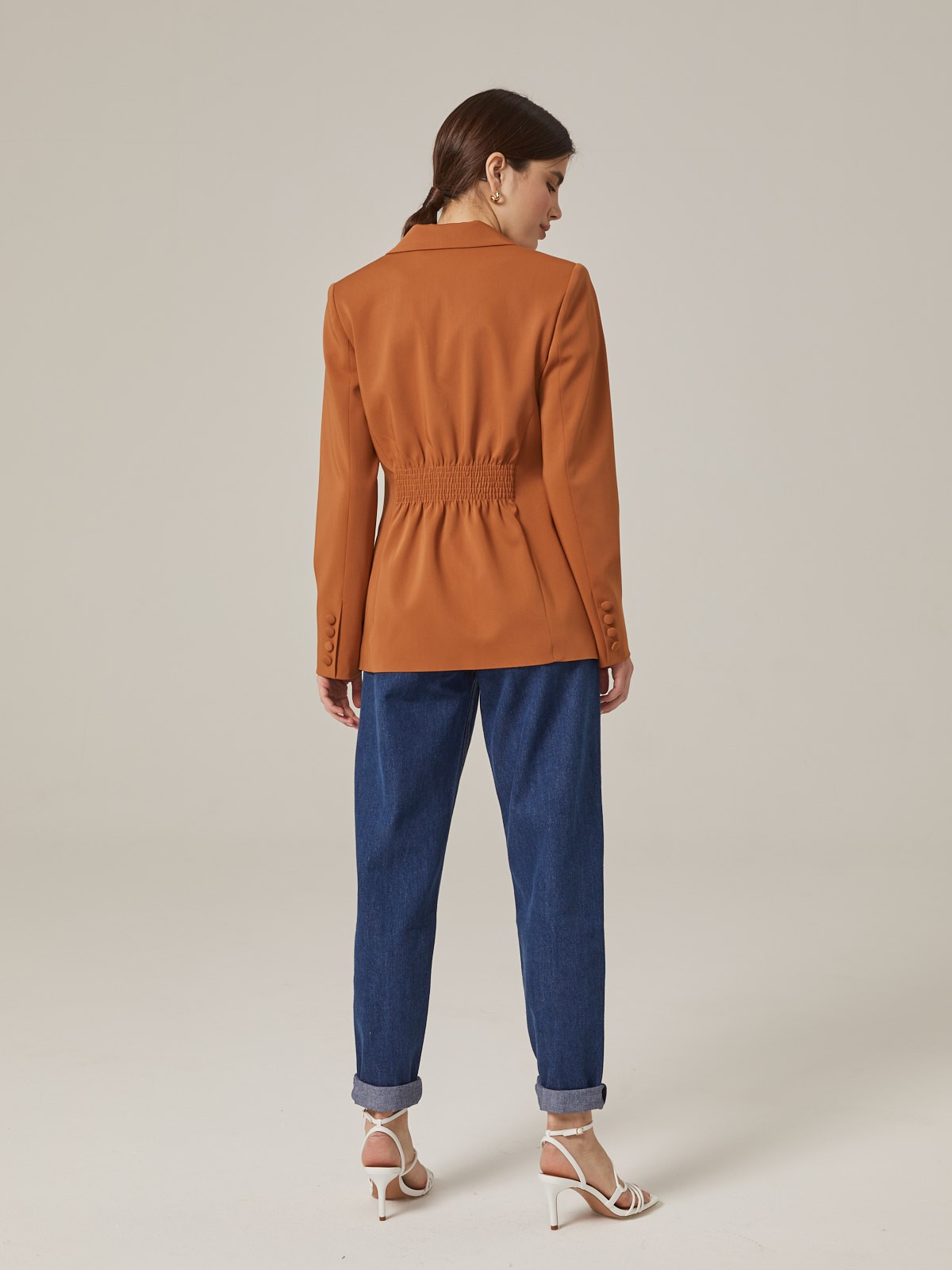 Приталенный двубортный жакет из мягкой костюмной ткани. Модель оформлена заостренными лацканами и обтяжными пуговицами в тон основной ткани. По бокам - карманы с клапанами, сзади - резинка, придающая акцент талии. Носите с базовой футболкой и джинсами или поверх элегантного вечернего платья.

На модели размер XS