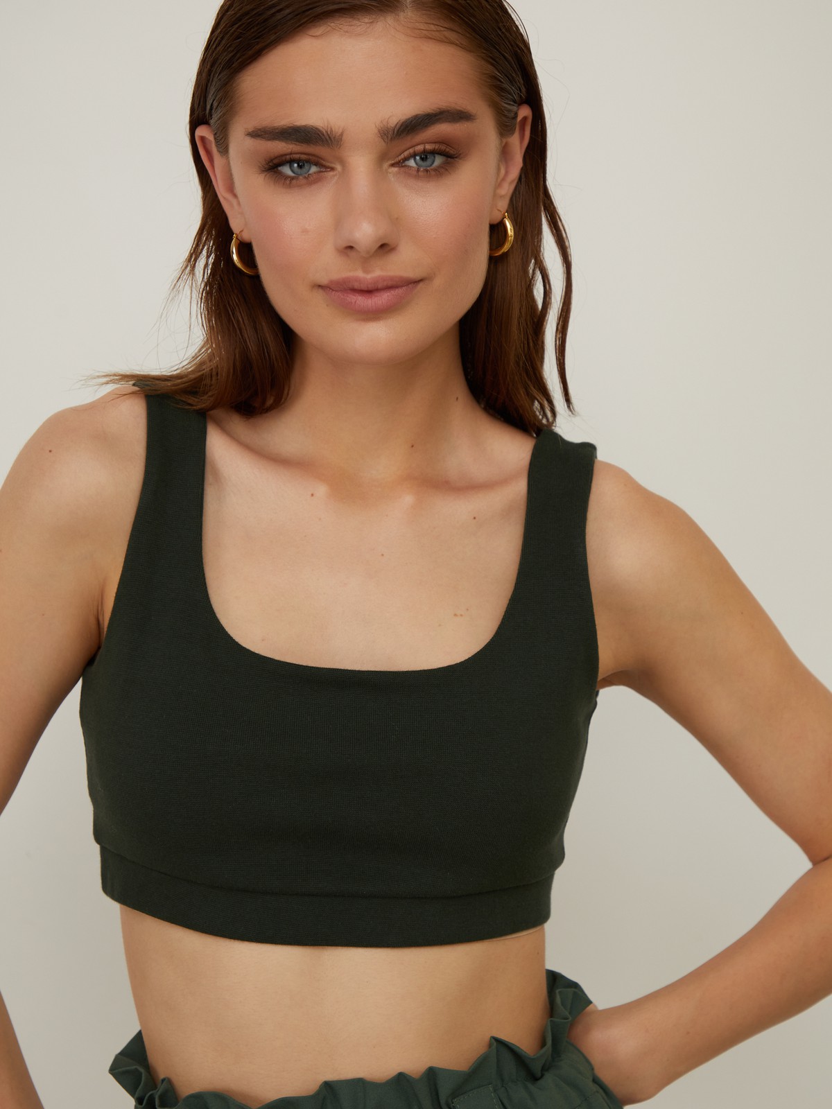 Укороченный топ облегающего кроя выполнен из двухслойной мягкой хлопковой ткани. Ткань топа плотная, что позволит носить его без нижнего белья. Квадратный вырез и широкие бретели подчеркивают плечи и линию декольте.

На модели размер XS