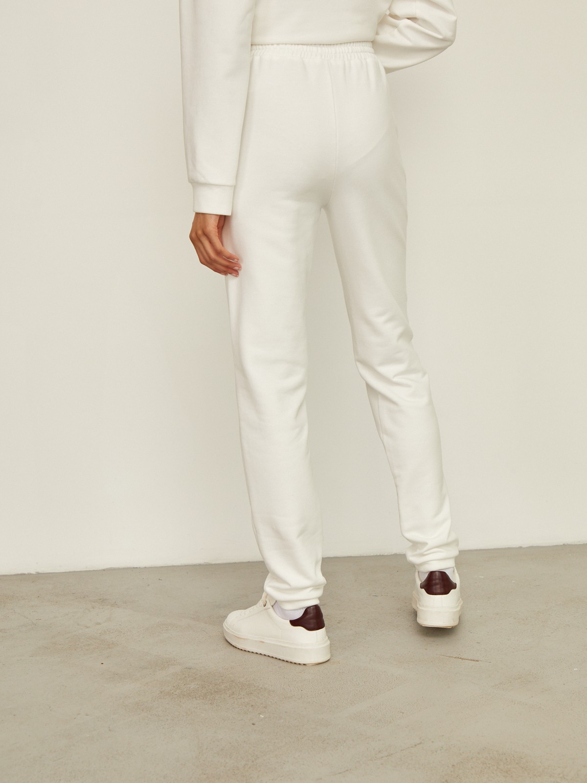 Брюки свободного спортивного силуэта. Модель дополнена манжетами из основной ткани по низу изделия и карманами по боковым швам. На поясе у брюк пояс, регулируемый завязками. Дополните свой образ толстовкой в тон изделия.

На модели размер XS