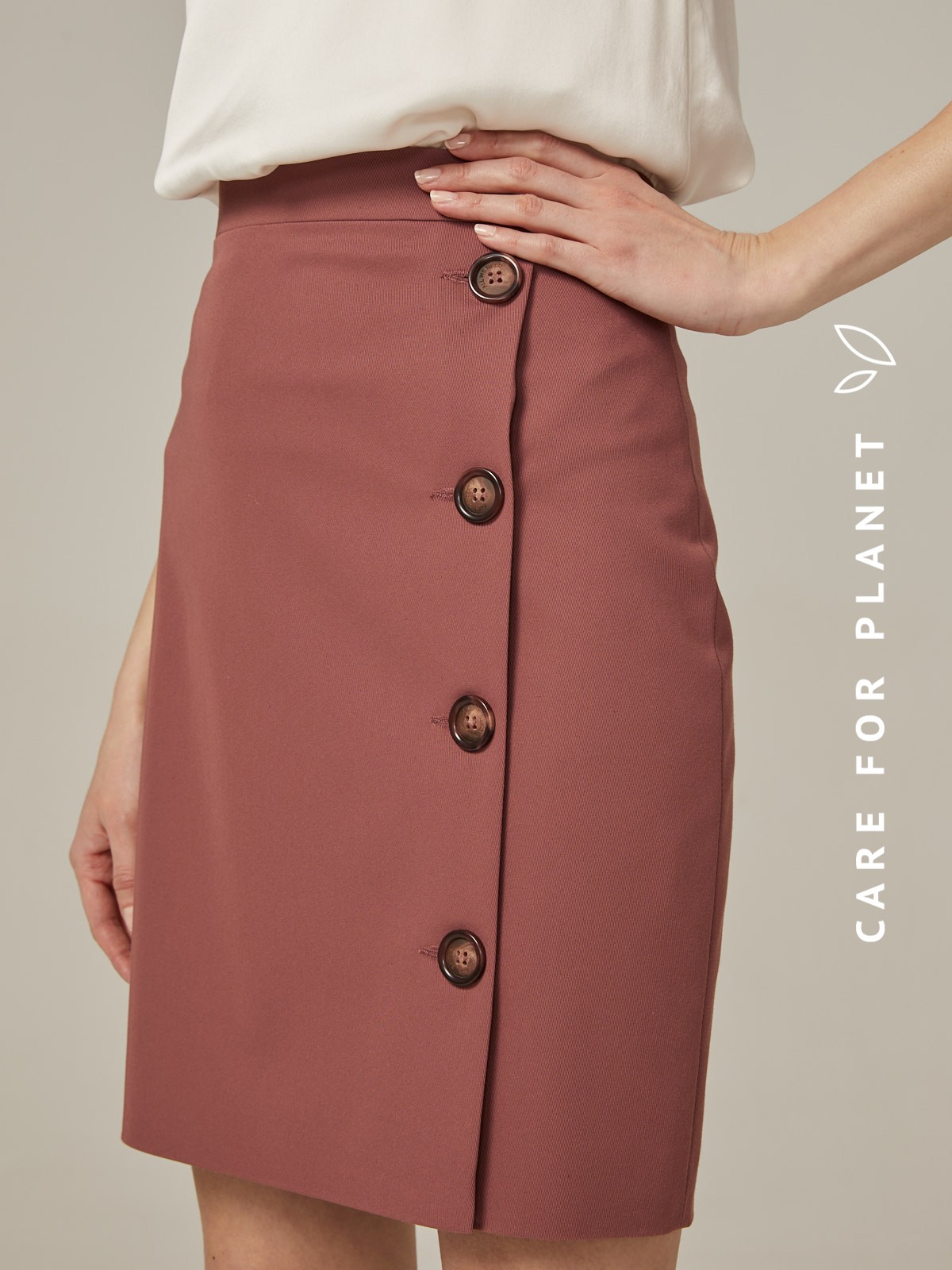 Прямая юбка длины мини на высокой посадке. модель дополнена 4 декоративными пуговицами по левому боку. Верхний срез обработан отрезным поясом.
Цветомодели кэмел и терракотовый на 35% выполнены из переработанного пластика.

На модели размер XS

