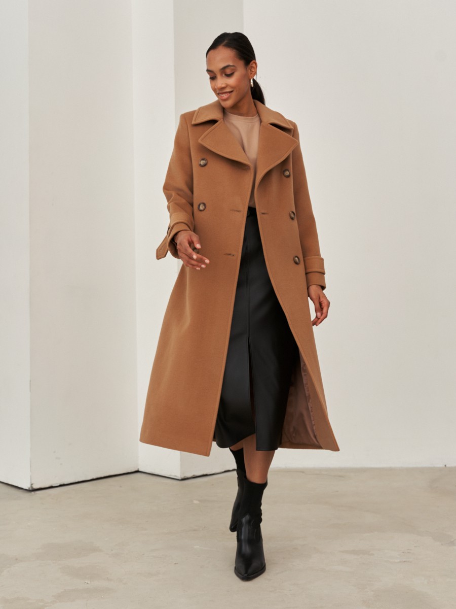 Двубортное пальто-тренчс кокеткой по спинке, широким поясом на пуговицах и шлицей сзади.
Рукава декорированы патами на пуговицах. Классический крой в сочетании с элементами стиля милитари - отличная альтернатива минимализму.

На модели размер XS