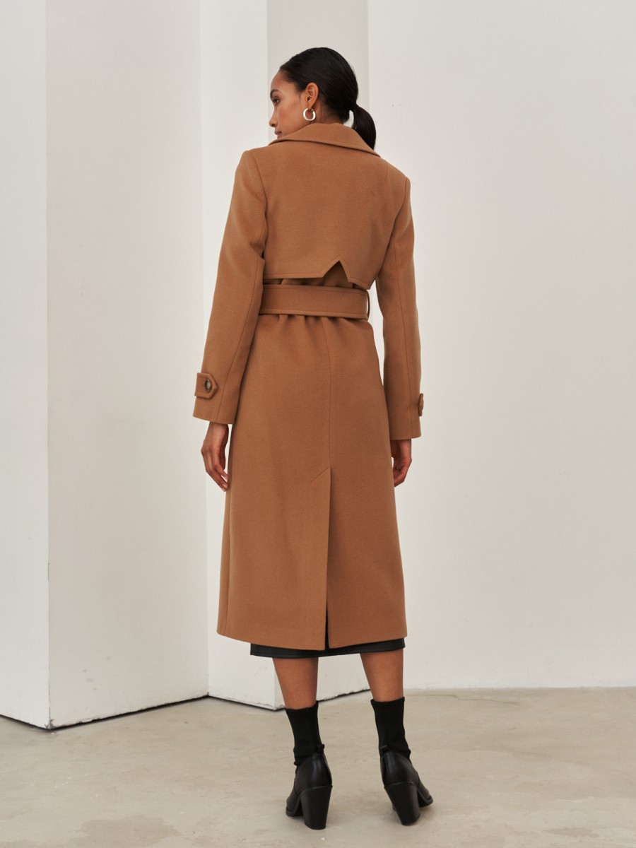 Двубортное пальто-тренчс кокеткой по спинке, широким поясом на пуговицах и шлицей сзади.
Рукава декорированы патами на пуговицах. Классический крой в сочетании с элементами стиля милитари - отличная альтернатива минимализму.

На модели размер XS