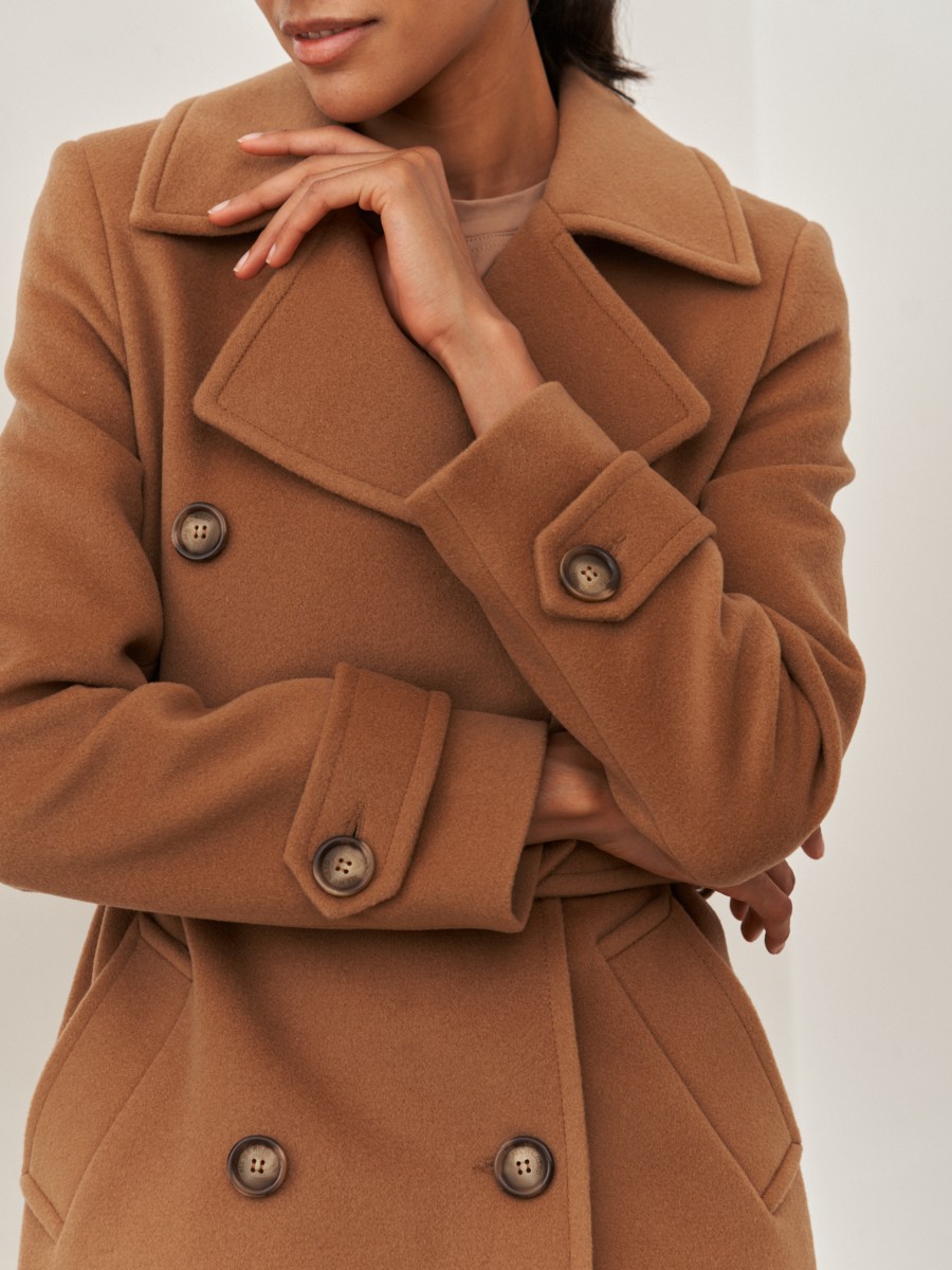 Двубортное пальто-тренчс кокеткой по спинке, широким поясом на пуговицах и шлицей сзади.
Рукава декорированы патами на пуговицах. Классический крой в сочетании с элементами стиля милитари - отличная альтернатива минимализму.

На модели размер XS