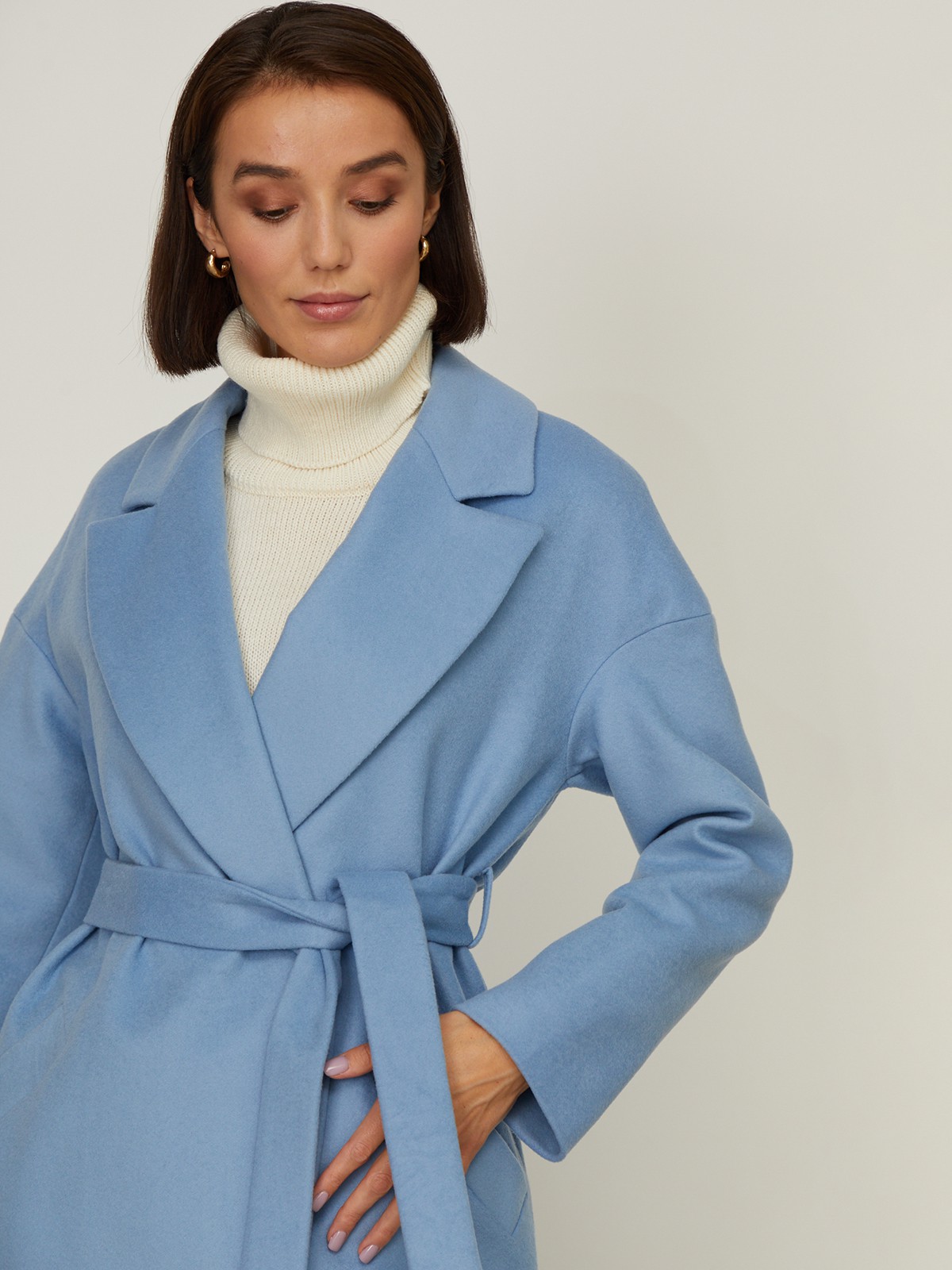 Пальто-халат из плотной шерсти. Модель прямого силуэтас английским воротником.Пальто дополнено двумя вместительными карманами,без застежки, с поясом из основного материала.

На модели размер XS