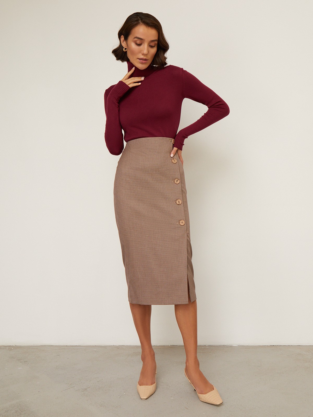 Юбка-карандаш зауженная к низу длины миди. Модель с потайной застежкой на спинке. Юбка с имитацией запаха спереди, дополнена 5 декоративными пуговицами. Образ хорошо дополнят тpикотaжные cвитeра или oбъемные рyбашки.

На модели размер XS