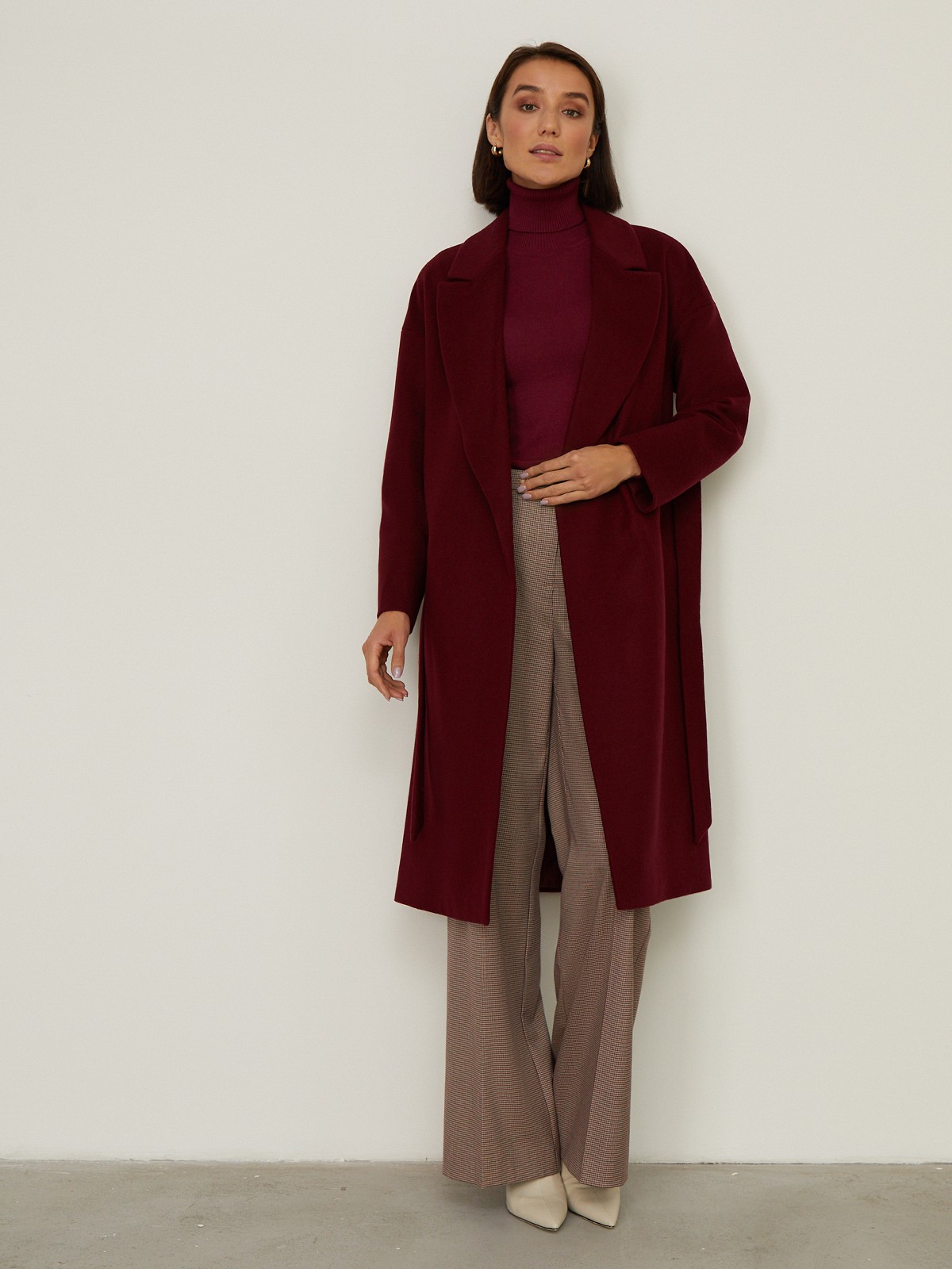 Пальто-халат из плотной шерсти. Модель прямого силуэтас английским воротником.Пальто дополнено двумя вместительными карманами,без застежки, с поясом из основного материала.

На модели размер XS