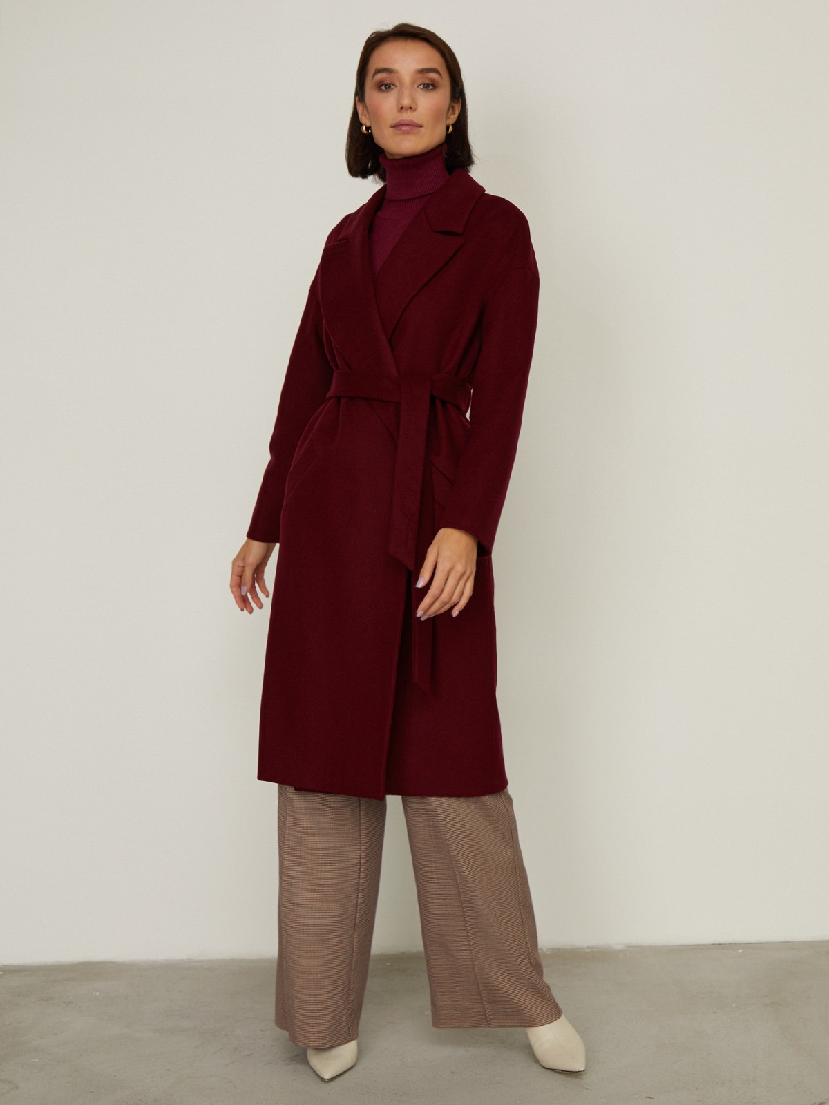 Пальто-халат из плотной шерсти. Модель прямого силуэтас английским воротником.Пальто дополнено двумя вместительными карманами,без застежки, с поясом из основного материала.

На модели размер XS