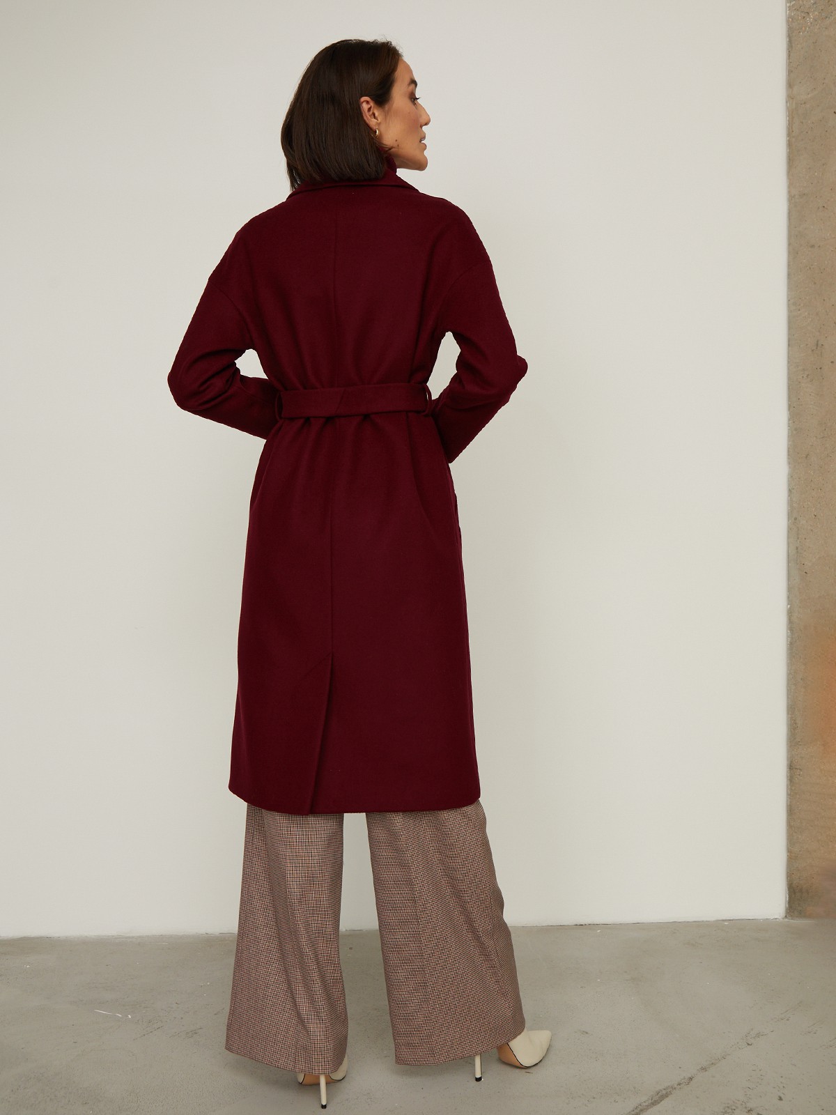 Пальто-халат из плотной шерсти. Модель прямого силуэтас английским воротником.Пальто дополнено двумя вместительными карманами,без застежки, с поясом из основного материала.

На модели размер XS