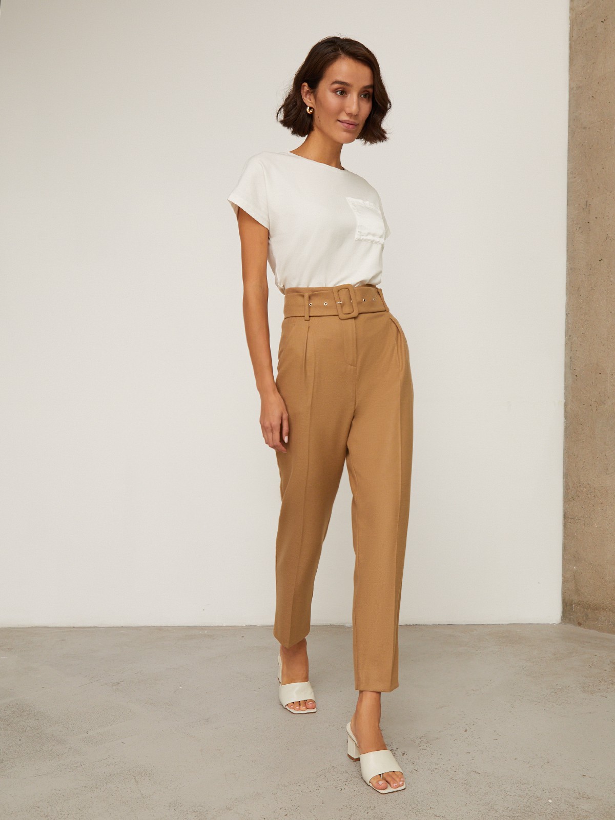 Брюки зауженные с завышенной посадкой, цвет: кэмел Allweneed Слегка зауженные брюки на высокой талии. Дополнены поясом с трендовой в этом сезоне роговой пряжкой. Сочетайте с однотонным жакетом из комплекта для создания изысканного, делового или вечернего образа. Брюки этой модели выпускаются в нашей коллекции уже несколько сезонов подряд, поэтому их посадка безупречна.
На модели размер XS