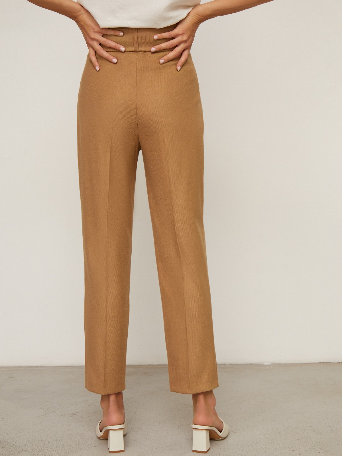 Брюки зауженные с завышенной посадкой, цвет: кэмел Allweneed Слегка зауженные брюки на высокой талии. Дополнены поясом с трендовой в этом сезоне роговой пряжкой. Сочетайте с однотонным жакетом из комплекта для создания изысканного, делового или вечернего образа. Брюки этой модели выпускаются в нашей коллекции уже несколько сезонов подряд, поэтому их посадка безупречна.
На модели размер XS